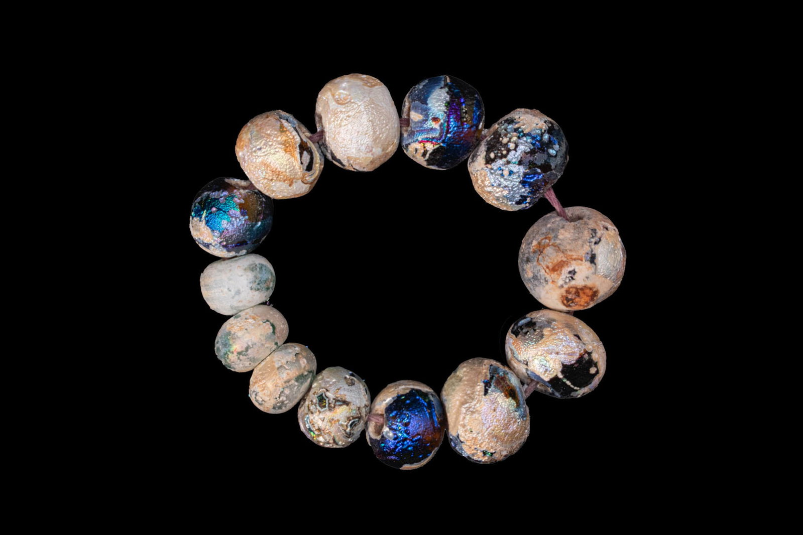 GREEK GLASS BEAD BRACELET: Ca. 300 - 100 BC. A bracelet composed of 13 rounded blue glass beads graduating in size. Size: 110mm x 25mm; Weight: 95g Provenance: Prince Collection, 1990s–2014; ex. private collection, 1970s–19