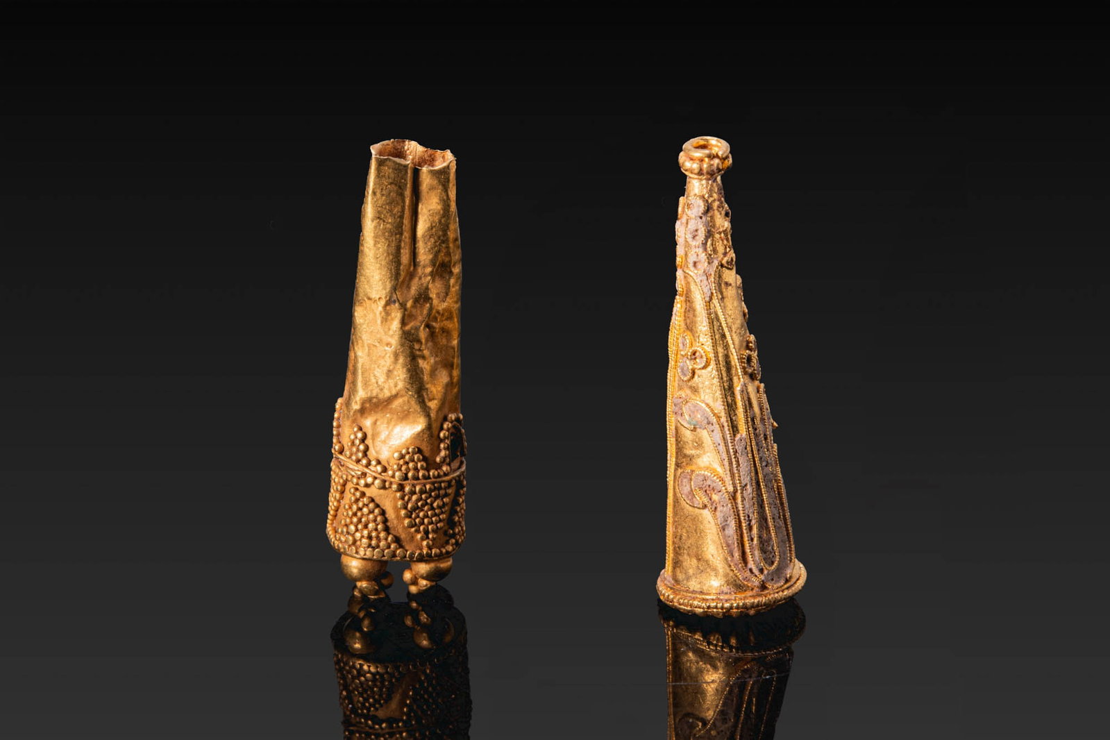 PAIR OF ROMAN GOLD PENDANTS: Ca. AD 200. A pair of gold conical pendants, from left to right: a pendant of thin sheet with the lower section bisected by a wire band and decorated with two rows of triangular clusters of granulatio