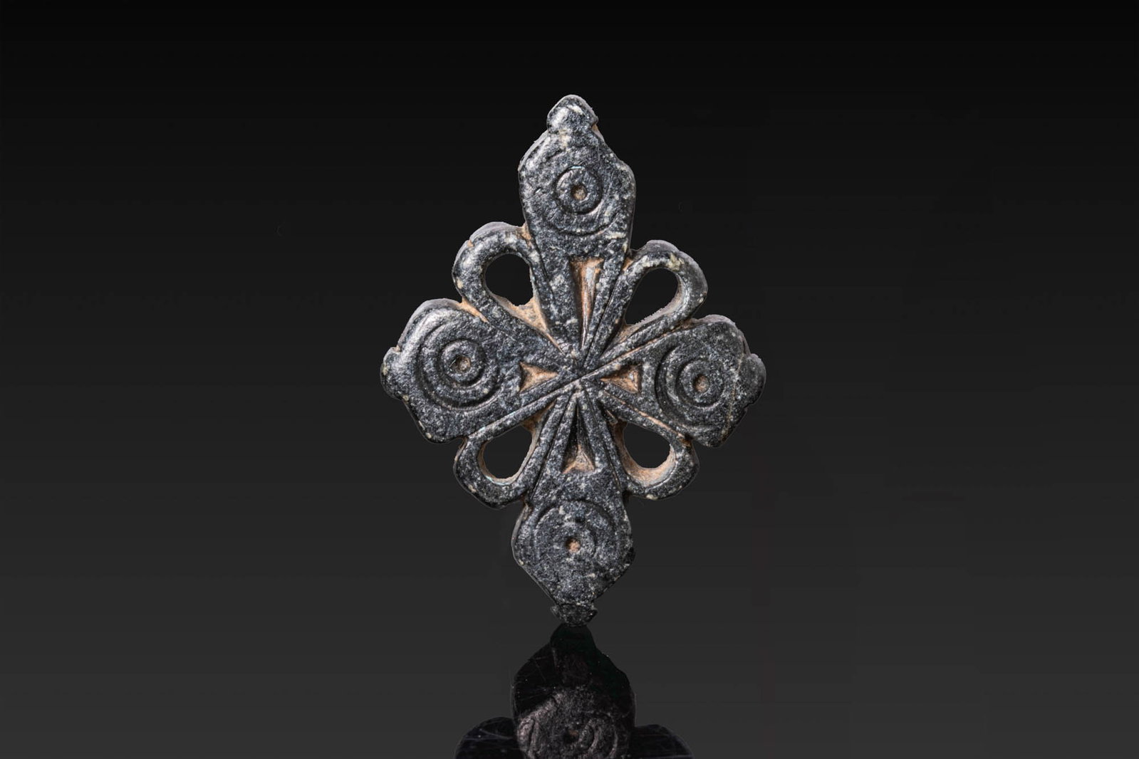 BYZANTINE OPENWORK STONE CROSS: Ca. AD 500. An openwork stone cross with expanding arms, each terminal carved with a concentric circle motif. Petal-shaped openings are cut between the arms, and the centre is formed with four small c