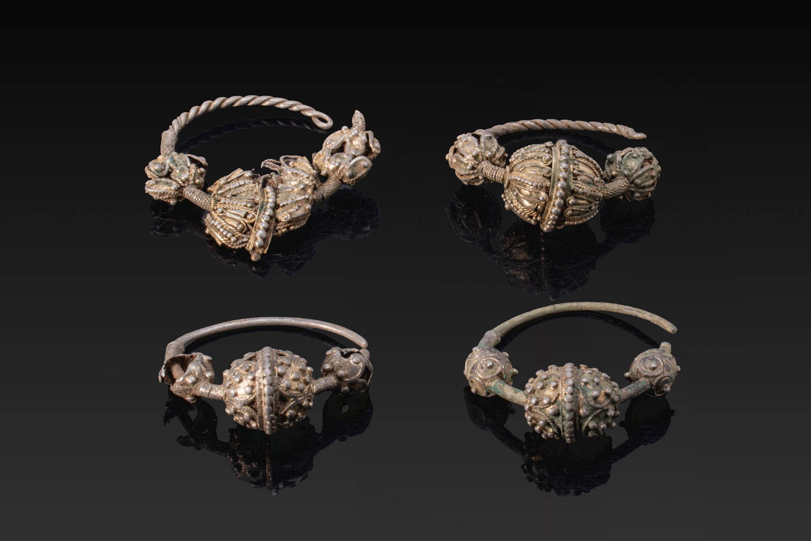 COLLECTION OF VIKING PERIOD SILVER EARRINGS: Ca. AD 700 - 1100. A collection of silver earrings, including a pair with twisted wire hoops and a pair with plain hoops, both centred by a large hollow bead with applied filigree and granulation, fla