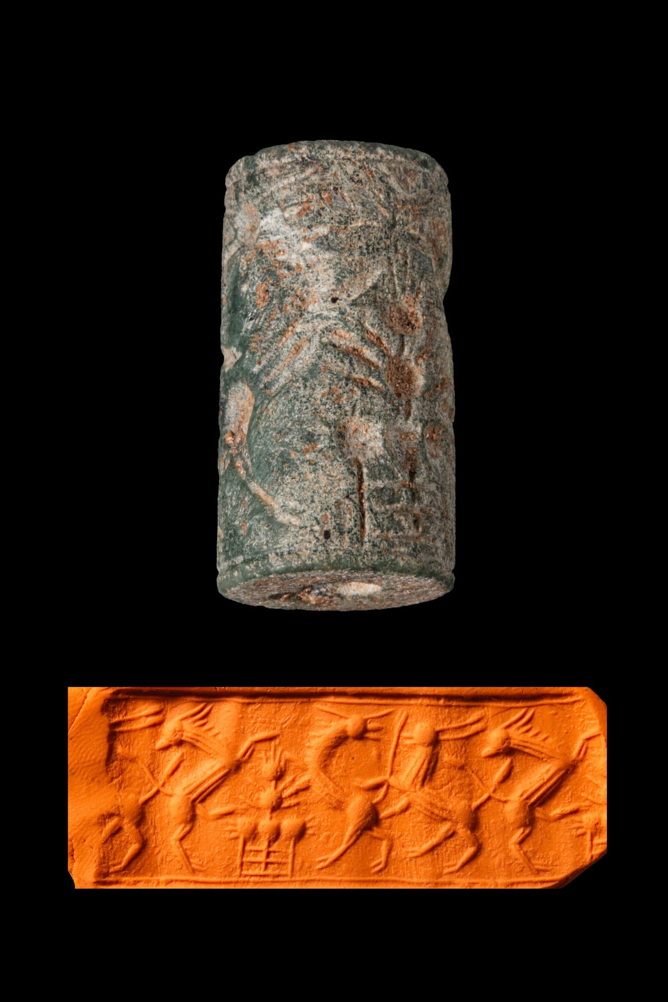 CENTRAL ASIAN GREENISH STONE CYLINDER SEAL WITH GAZELLES AND A FLORAL MOTIF: Ca. 2000 - 1 BC. A greenish stone cylinder seal, drilled longitudinally and engraved with three gazelles, with a floral motif above an altar. Size: 26mm x 14mm; Weight: 9g Provenance: Private London c