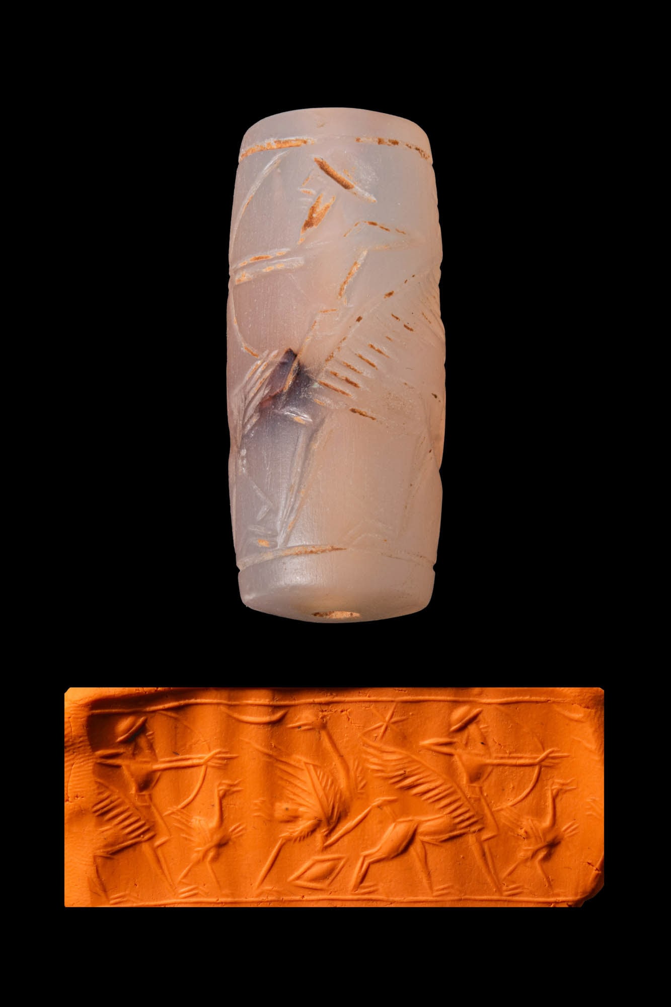 NEO-ASSYRIAN QUARTZ BARREL-SHAPED CYLINDER SEAL WITH A WINGED MYTHICAL CREATURE AND OSTRICHES: Ca. 800 - 700 BC. A quartz barrel-shaped cylinder seal, drilled longitudinally and engraved with a human-headed mythical creature with a winged lion body shooting arrows at ostriches. A six-pointed st