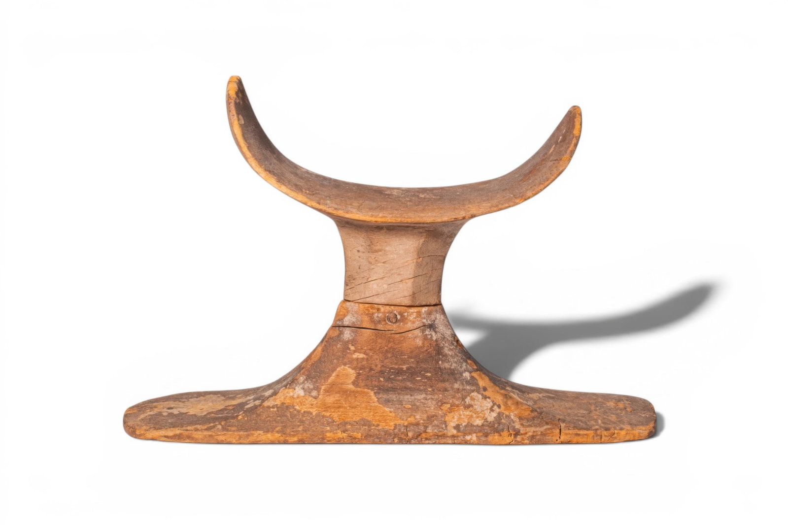 EGYPTIAN WOOD HEADREST: Old Kingdom, Ca. 2707 - 2016 BC. A wood headrest made in two separately carved parts, with a curved crescent-shaped rest supported by a tapering central shaft above a broad flat base with sloping side