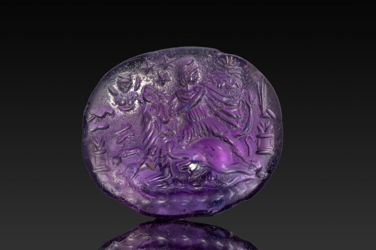 ROMAN AMETHYST INTAGLIO WITH TAUROCTONY - MITHRAS SLAYING THE BULL: Ca. AD 1 - 50. An amethyst oval intaglio engraved with Mithras in a Phrygian cap and billowing cloak, leaning to the left as he slays the bull, his head turned away. A dog and a snake reach towards th