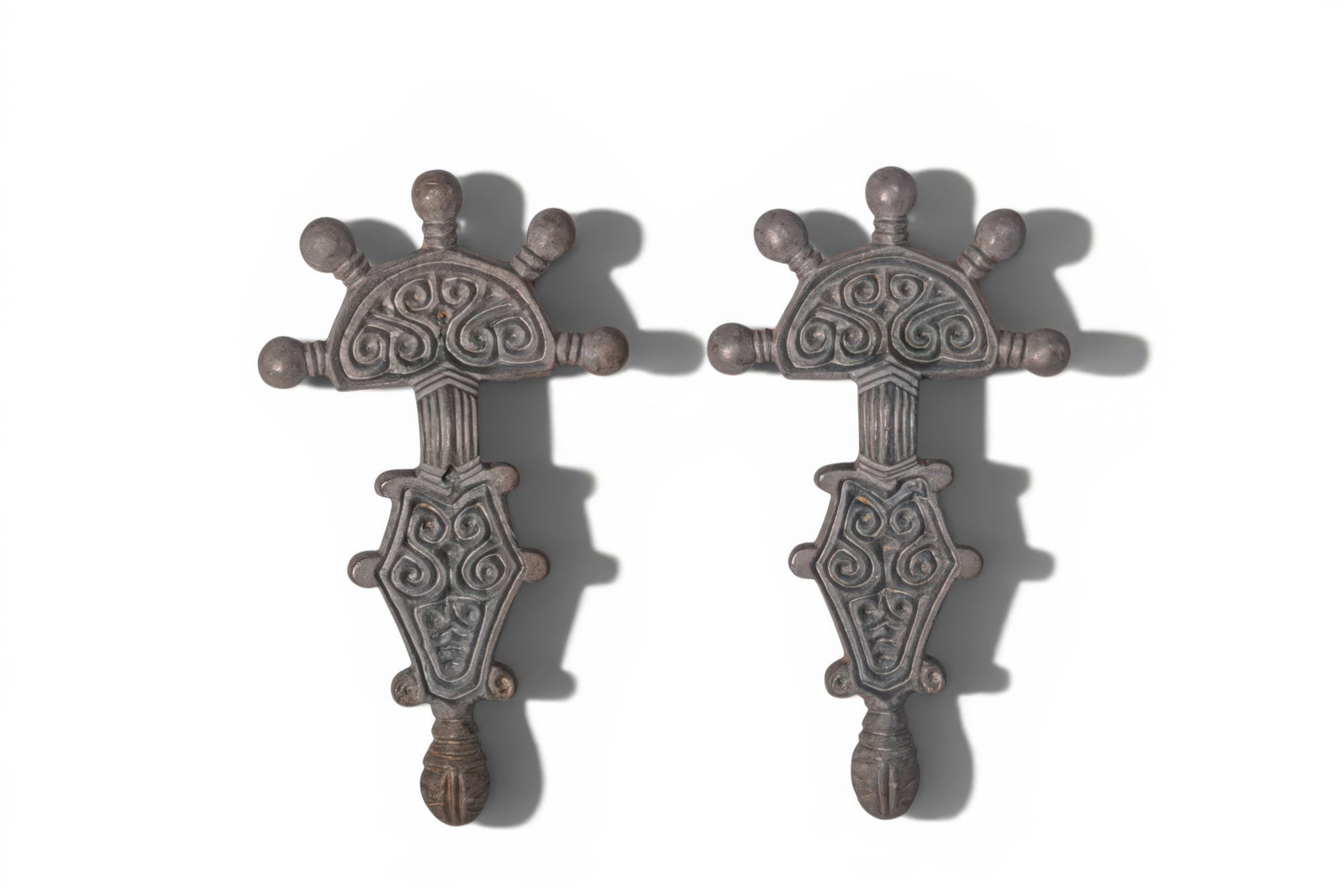 PAIR OF OSTROGOTHIC SILVER ALLOY FIBULAS: Ca. AD 500 - 600. A pair of silver fibulas, each composed of a half-round head plate surmounted by five knop terminals, above a short ribbed arched bow and a diamond-shaped foot with three lateral pro