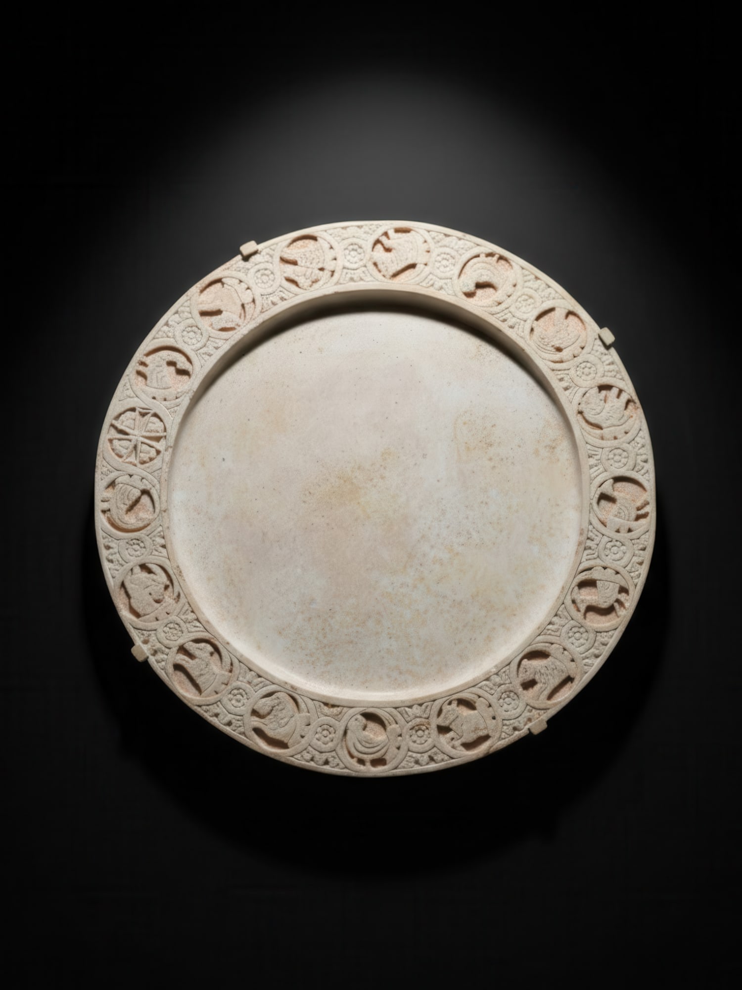 LARGE BYZANTINE MARBLE TABLE WITH CHRISTIAN SYMBOLS: Ca. AD 600 - 800. A large marble table with a circular recessed centre and a broad raised border carved with 17 roundels enclosing Christian symbols, Byzantine zodiac animals, and birds shown in profi