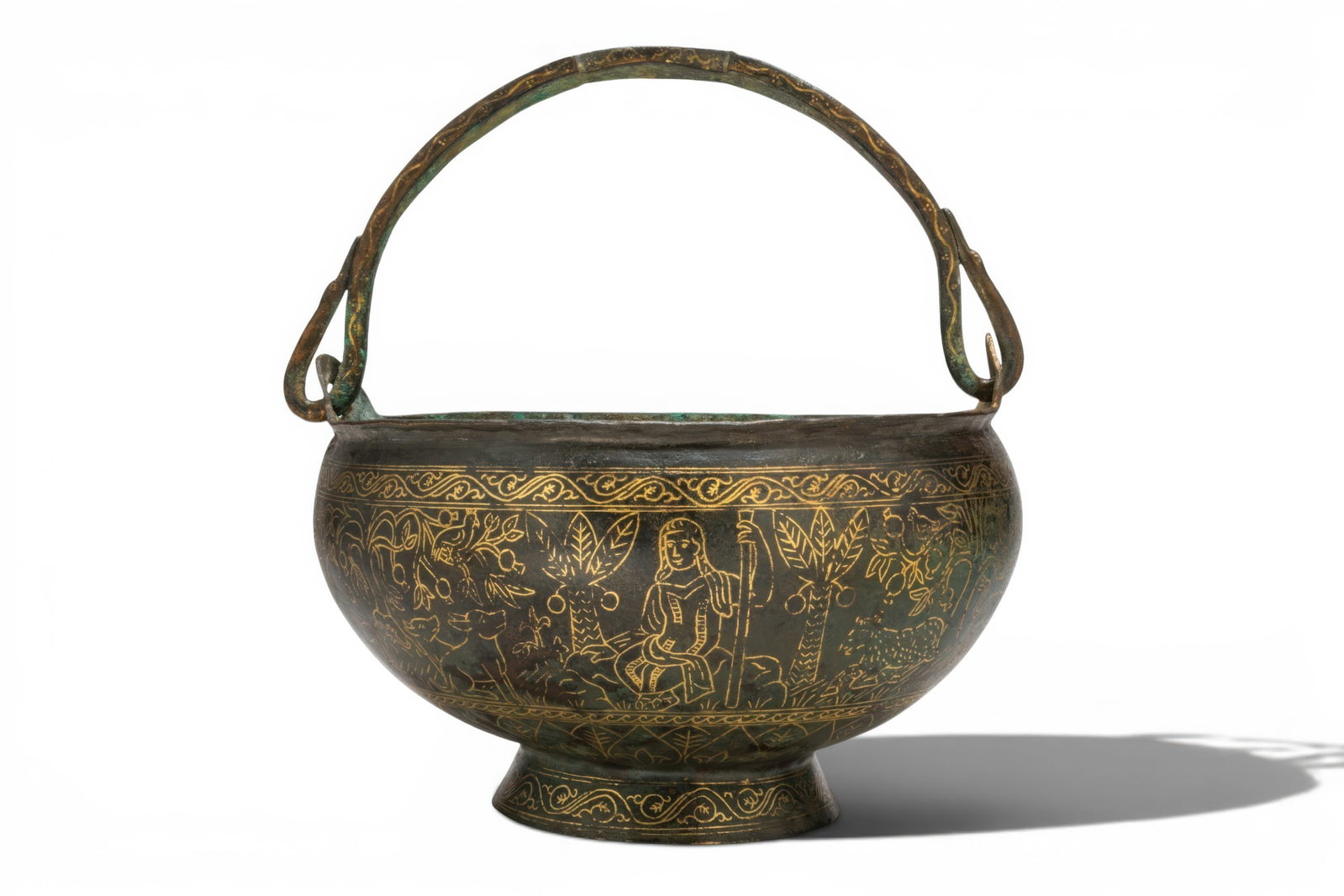 BYZANTINE LITURGICAL GILT-BRONZE SITULA WITH CHRIST AND ANIMALS: Ca. AD 400 - 500. A gilt-bronze situla with a broad mouth, a deep rounded body, a flaring foot, and a swing handle attached at opposed side lugs, decorated with vine scrolls and clustered pellets, wit