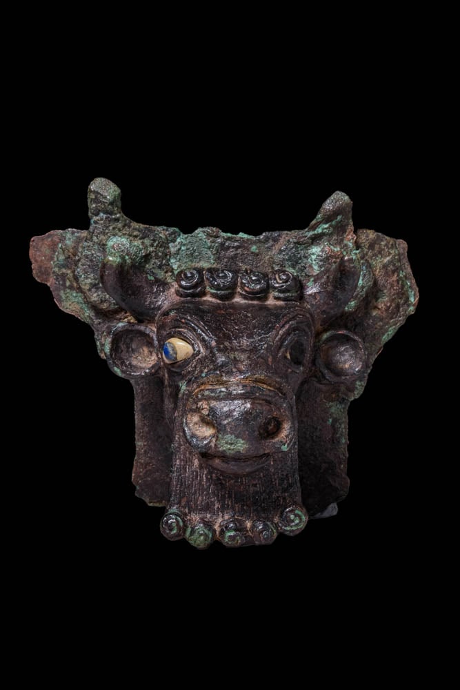 SUPERB SUMERIAN BULL BRONZE PROTOME WITH INLAID EYES: Ca. 2600 - 1350 BC. A bronze bull head protome with short curving horns, rounded ears and a broad projecting muzzle. The eyes are inlaid with white stone and lapis lazuli, set beneath sharply arched l