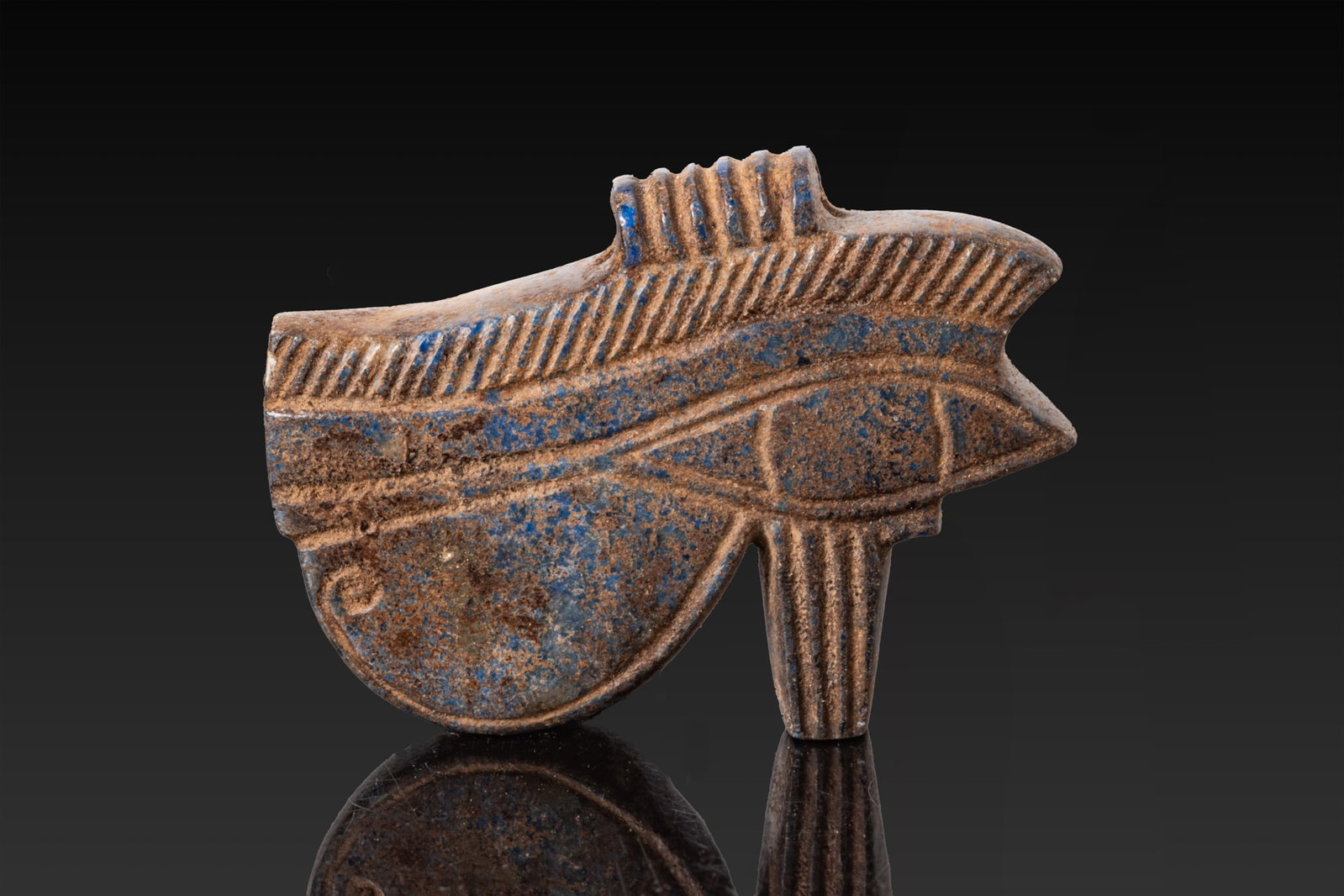 RARE EGYPTIAN LAPIS LAZULI WEDJAT EYE AMULET: Late Period, Ca. 664 - 332 BC. A lapis lazuli wedjat eye amulet with an almond-shaped eye, a long tapering cosmetic line, and a curved cheek marking below. The eyebrow is marked with short diagonal li