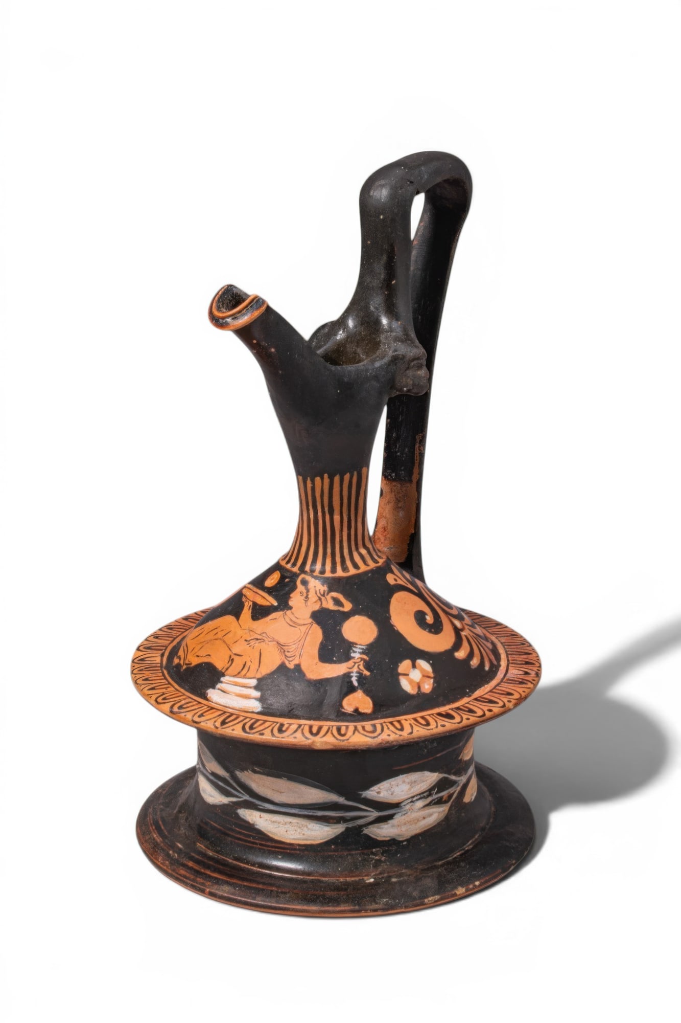 APULIAN RED-FIGURE EPICHYSIS WITH A SEATED MAENAD: Ca. 400 - 300 BC. A red-figure epichysis with a spool-shaped body, domed shoulder, slender neck, oblique mouth, and high strap handle. The shoulder is decorated with a seated maenad on a pile of rocks