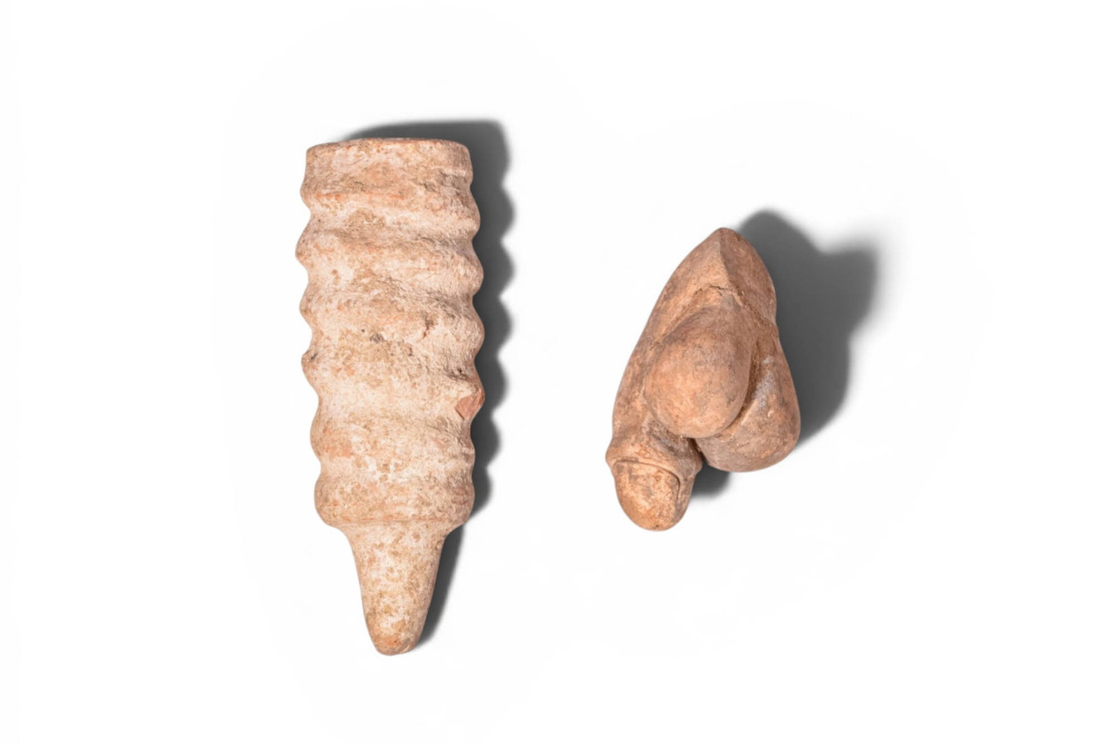 PAIR OF ETRUSCAN AND ROMAN STONE AND TERRACOTTA PHALLIC AMULETS (1 of 3)