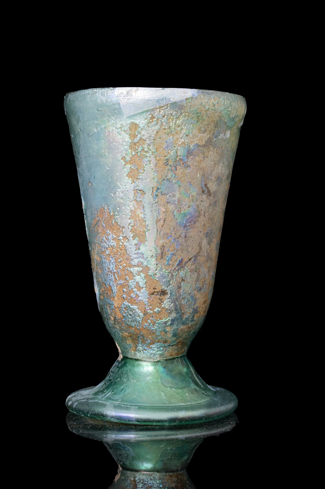 ROMAN TRANSLUCENT GLASS BEAKER: Ca. AD 300 - 500. A green glass beaker on a hollow, splayed foot. The body rises to a broad open mouth. For similar see: R. A. Grossmann, Ancient Glass, A Guide to the Yale Collection, fig. 28. Size: 