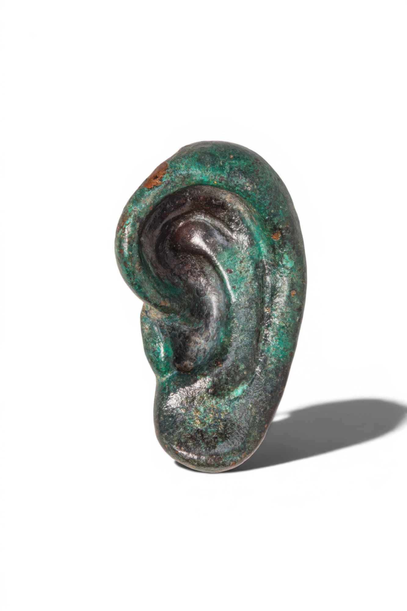 ROMAN BRONZE VOTIVE EAR: Ca. AD 100 - 300. A bronze votive ear, naturalistically modelled with a curved outer rim, recessed inner folds, and a rounded lobe. The reverse is flat and plain. For similar see: The Science Museum G