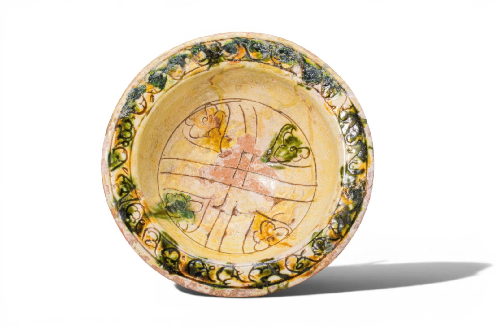 BYZANTINE GLAZED TERRACOTTA FOOTED BOWL WITH FLORAL MOTIFS - EX ASHMOLEAN MUSEUM COLLECTION: Ca. AD 1300 - 1500. A sgraffito terracotta footed bowl with a hemispherical body on a low spreading pedestal foot and an outturned rim. The interior is decorated with intersecting linear bands forming