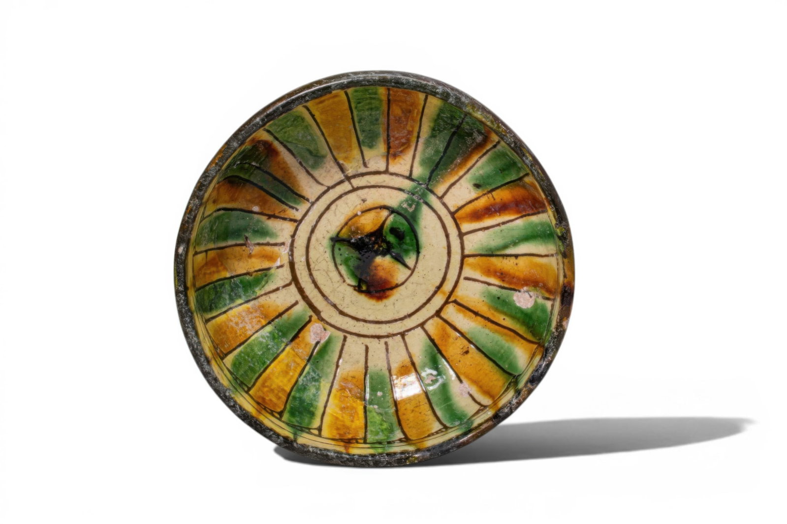 BYZANTINE GLAZED TERRACOTTA BOWL WITH CENTRAL MOTIF - EX ASHMOLEAN MUSEUM COLLECTION: Ca. AD 1300 - 1500. A glazed terracotta bowl with a deep, rounded body on a low pedestal foot. The exterior is coated with a dark slip. The interior is decorated with a radiating composition of elonga