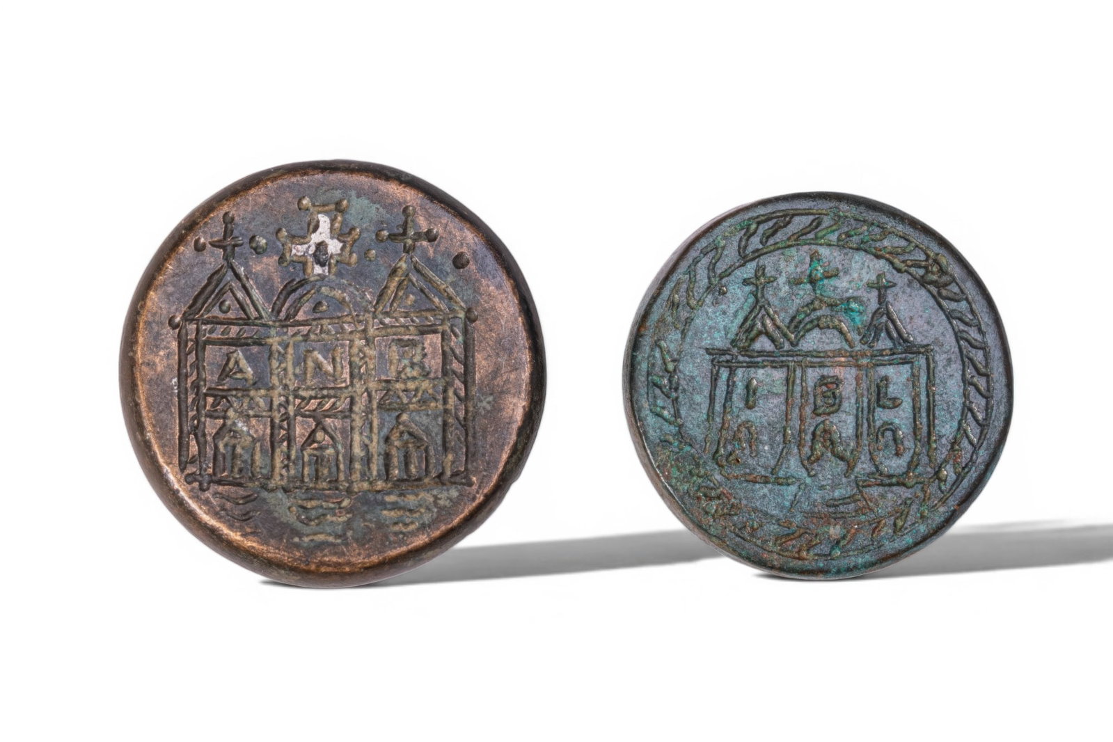 PAIR OF BYZANTINE BRONZE WEIGHTS WITH CATHEDRAL FACADES: Ca. AD 400 - 600. A pair of bronze weights, each circular and engraved with a stylised three-part cathedral faade, with two triangular roofs flanking a central dome, each section with an arched doorwa