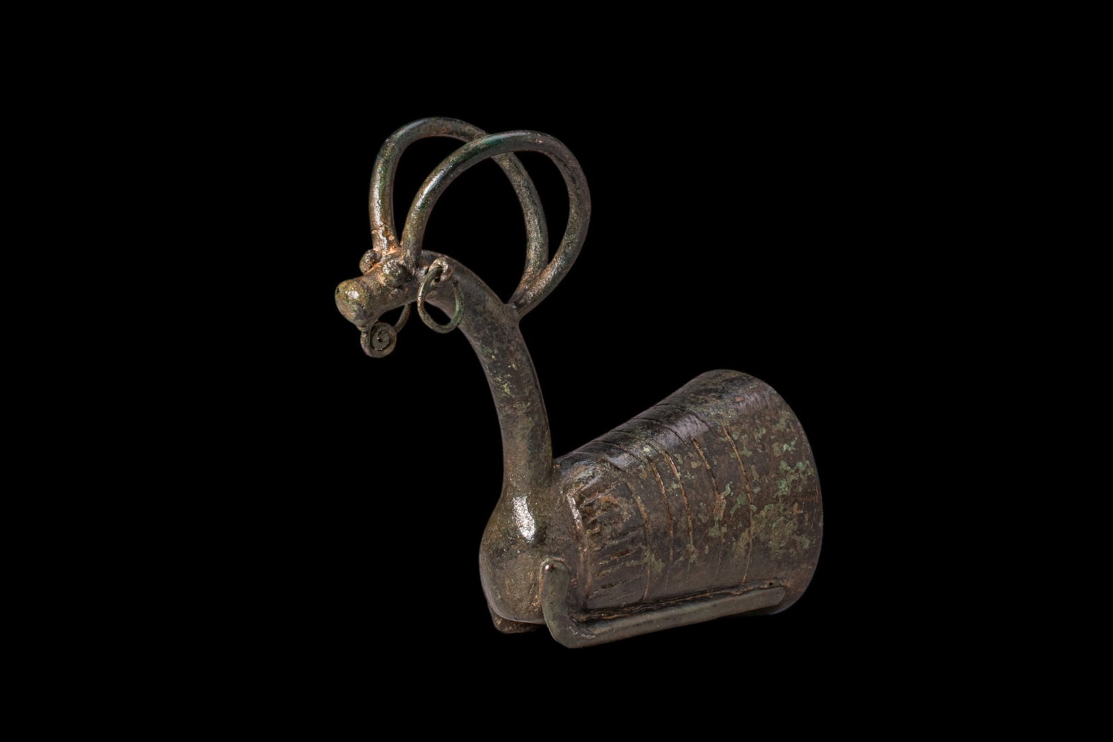 BRONZE AGE WHETSTONE WITH IBEX: Ca. 1200 - 800 BC. A bronze whetstone handle cast as the forepart of an ibex, with a tapering cylindrical socket marked with encircling grooves and a long curved neck ending in a small head with a sho