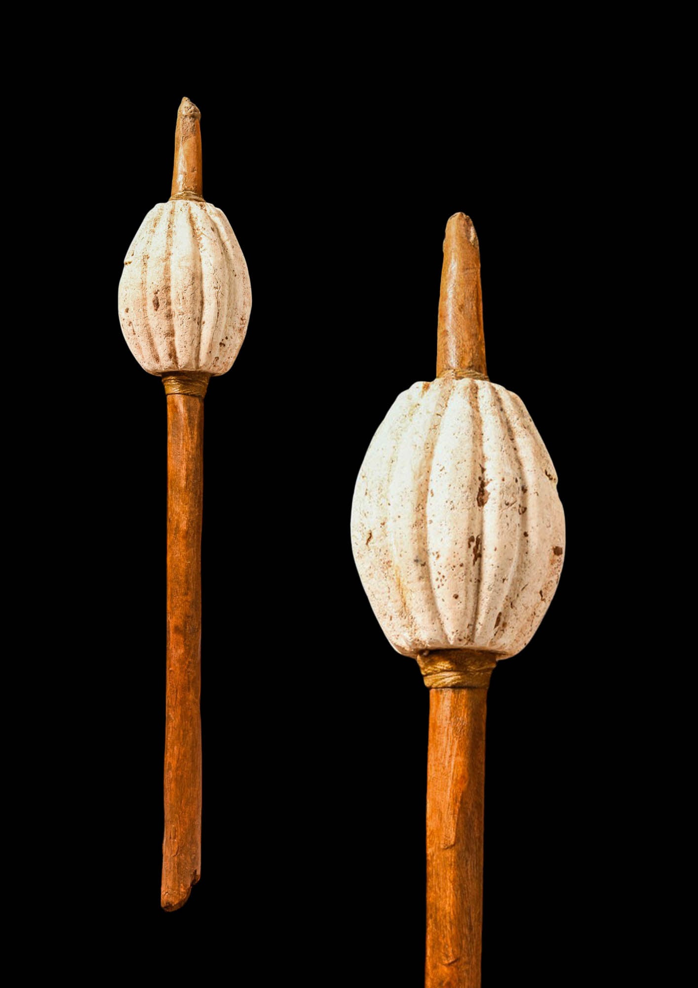 MESOPOTAMIAN STONE RIBBED MACE: Ca. 2200 - 1500 BC. A stone ribbed mace head carved as an ovoid bulb with deep vertical flutes, mounted on a wood shaft passing through the centre. A narrow binding collar encircles the junction betwe