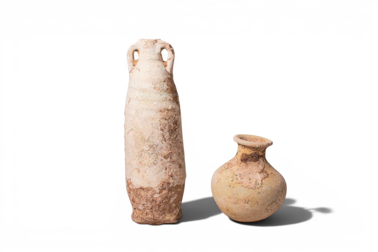 PAIR OF ROMANO-EGYPTIAN FAIENCE VESSELS: Ca. 200 BC - AD 100. A pair of faience vessels, from left to right: a tall, slender amphoriskos with a tapering body, a narrow neck, and a pair of small loop handles at the shoulder, the surface with 