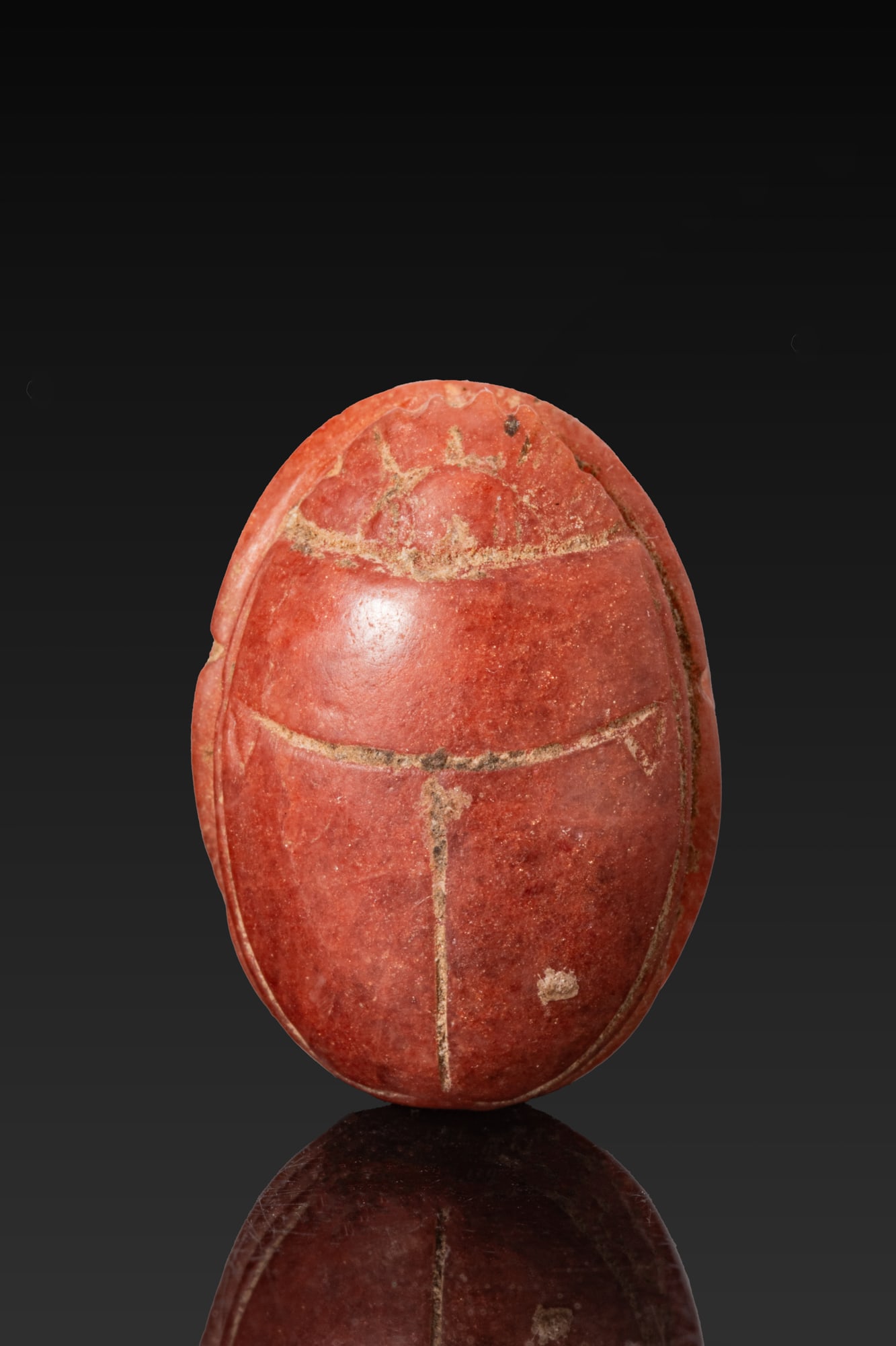 EGYPTIAN AGATE SCARAB: New Kingdom, Ca. 1550 - 1069 BC. An agate scarab with a domed back and a semi-circular head beneath a serrated clypeus, the prothorax separated from the wing cases, which are divided by an incised lon