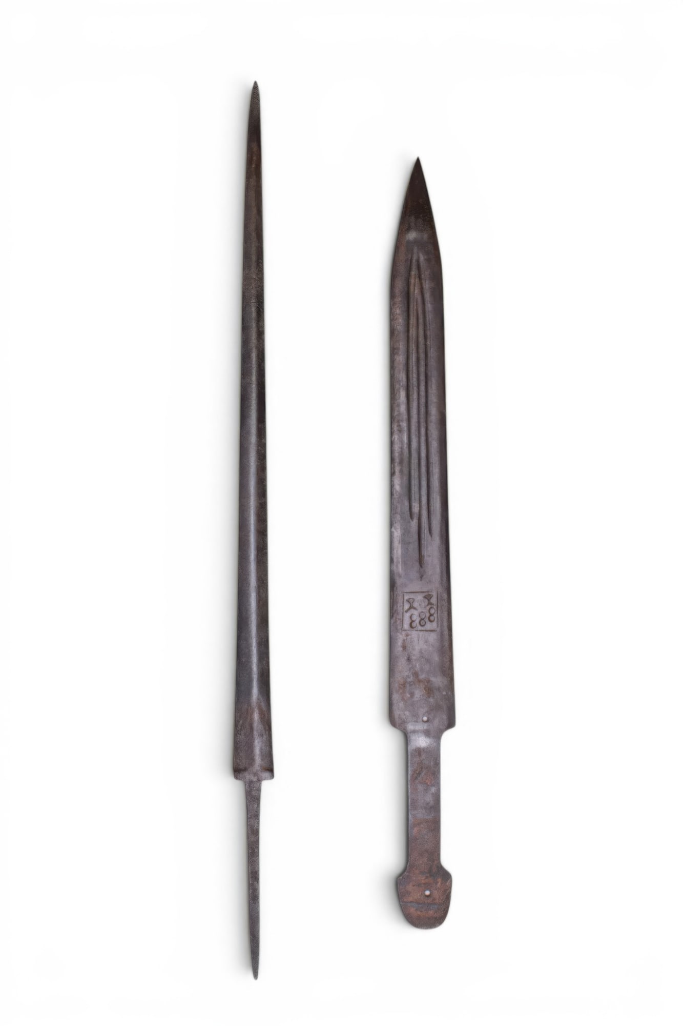 PAIR OF CELTIC IRON WEAPONS: Ca. 500 - 300 BC. A pair of iron weapons, including, from left to right: a long narrow thrusting blade with a sharp point and a slender tang; and a dagger with straight parallel sides tapering to a po