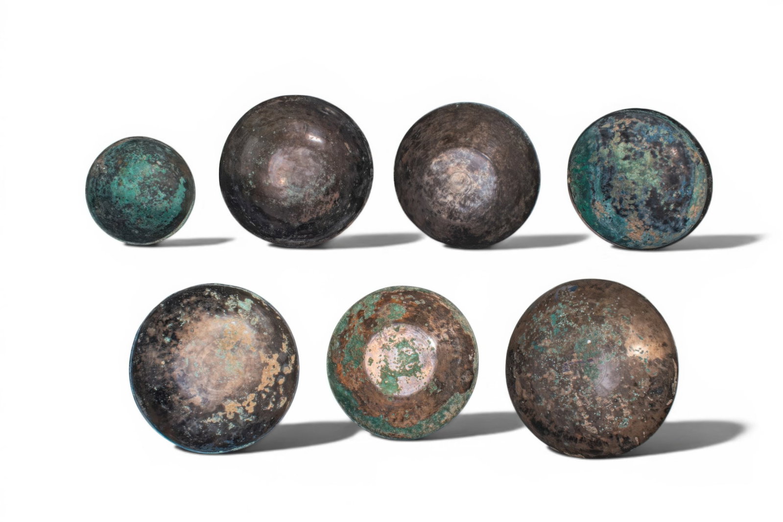 COLLECTION OF GREEK PERIOD BRONZE BOWLS: Ca. 500 BC. A collection of eight bronze bowls, each hammered from thin sheet bronze, with wide mouths, rounded sides, and either a rounded or a flat base. The surfaces are plain. Size: 120-190mm x 50