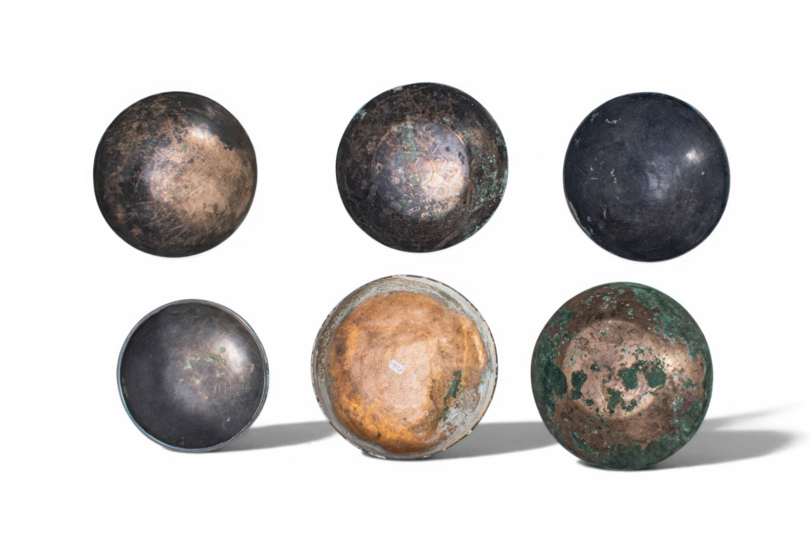 COLLECTION OF GREEK PERIOD BRONZE BOWLS: Ca. 500 BC. A collection of six bronze bowls, each hammered from thin sheet bronze, with wide mouths, rounded sides, and either a rounded or a flat base. The surfaces are plain. Size: 140-175mm x 35-5