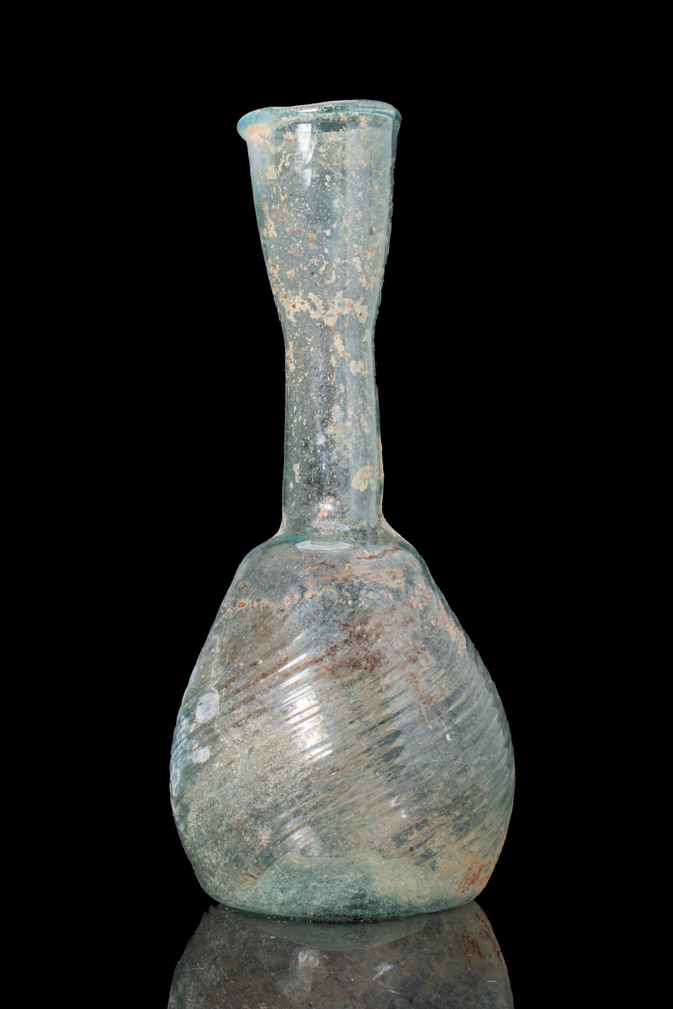 ROMAN SWIRLED GLASS FLASK: Ca. AD 1 - 300. A free-blown translucent pale blue-green glass flask with a pear-shaped body and a tall neck expanding to a flaring mouth. Size: 175mm x 80mm; Weight: 70g Provenance: Private UK collec