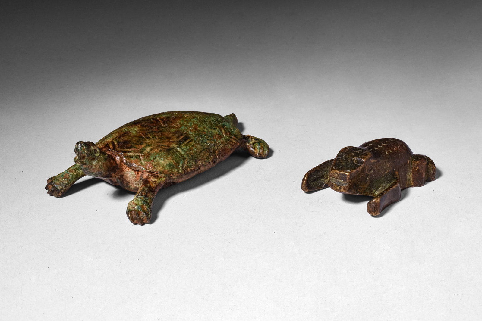 PAIR OF ROMAN BRONZE ANIMAL FIGURINES: Ca. AD 1 - 300. A pair of bronze animal figurines, including, from left to right: a tortoise cast with an oval domed shell engraved with the scutes, a projecting head, four splayed legs, and a taperin