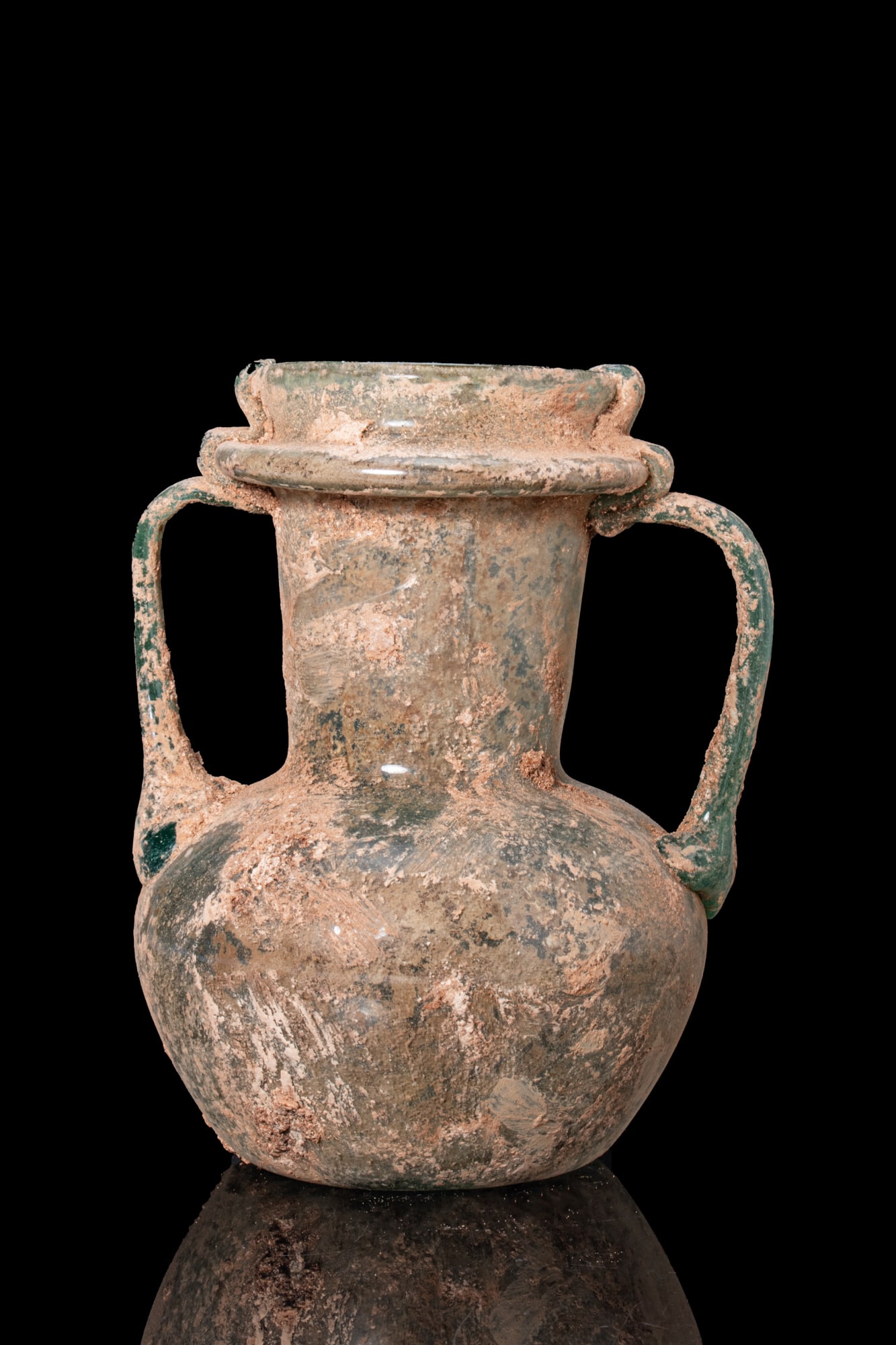 LATE ROMAN GLASS AMPHORISKOS: Ca. AD 300 - 500. A free-blown translucent pale green glass amphoriskos with a globular body, a concave base with a pontil mark, a tall flaring neck, and a collared mouth. A pair of strap handles is a