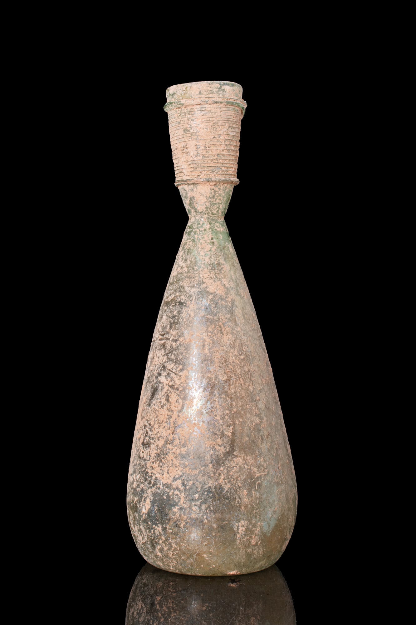 BYZANTINE GLASS BOTTLE: Ca. AD 600. A free-blown translucent pale green glass bottle with an elongated piriform body and a short cylindrical neck encircled by closely wound applied threads below the mouth. Size: 210mm x 75mm