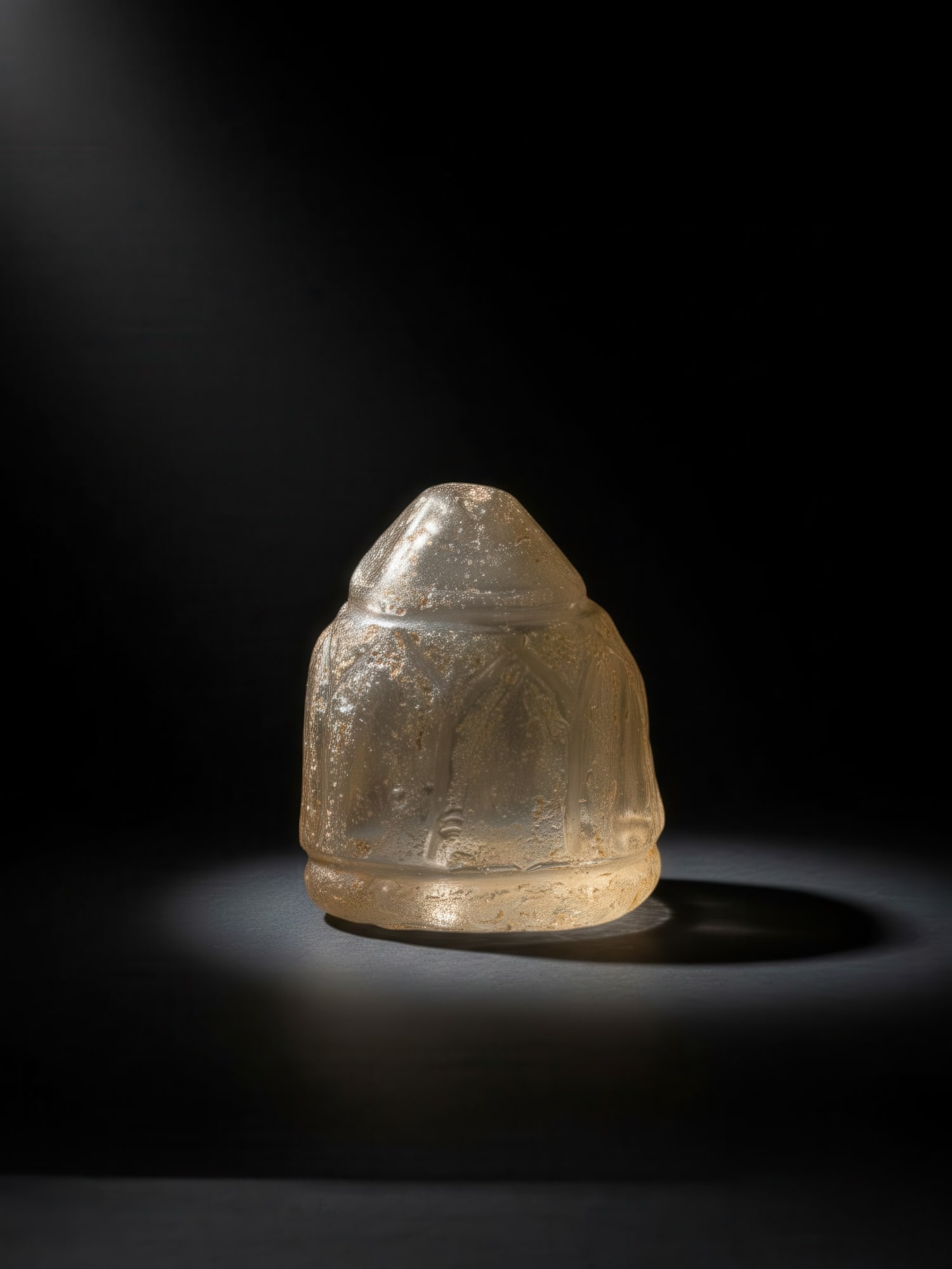 FATIMID ROCK CRYSTAL CHESS PIECE: Ca. AD 1000 - 1100. A rock crystal chess piece of flattened tapering body with a rounded base and a domed top, the sides cut with a series of pointed arched panels between narrow collars. Size: 30mm x