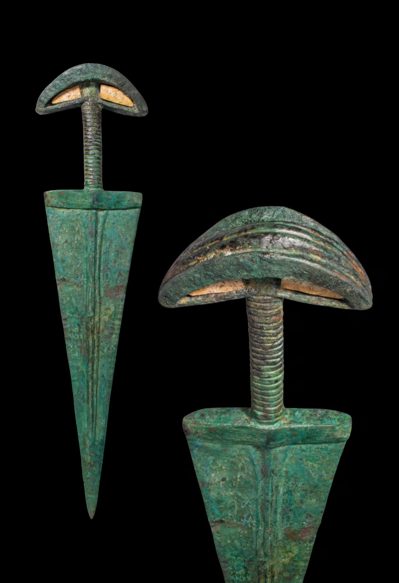 HUGE BRONZE AGE RITUAL DAGGER WITH CRESCENTIC POMMEL INLAID WITH STONE: Ca. 1200 BC. A bronze ritual dagger with a triangular blade tapering to a sharp point. Each face has three pronounced ribs converging into a single rib before the tip. The shoulders are straight and a