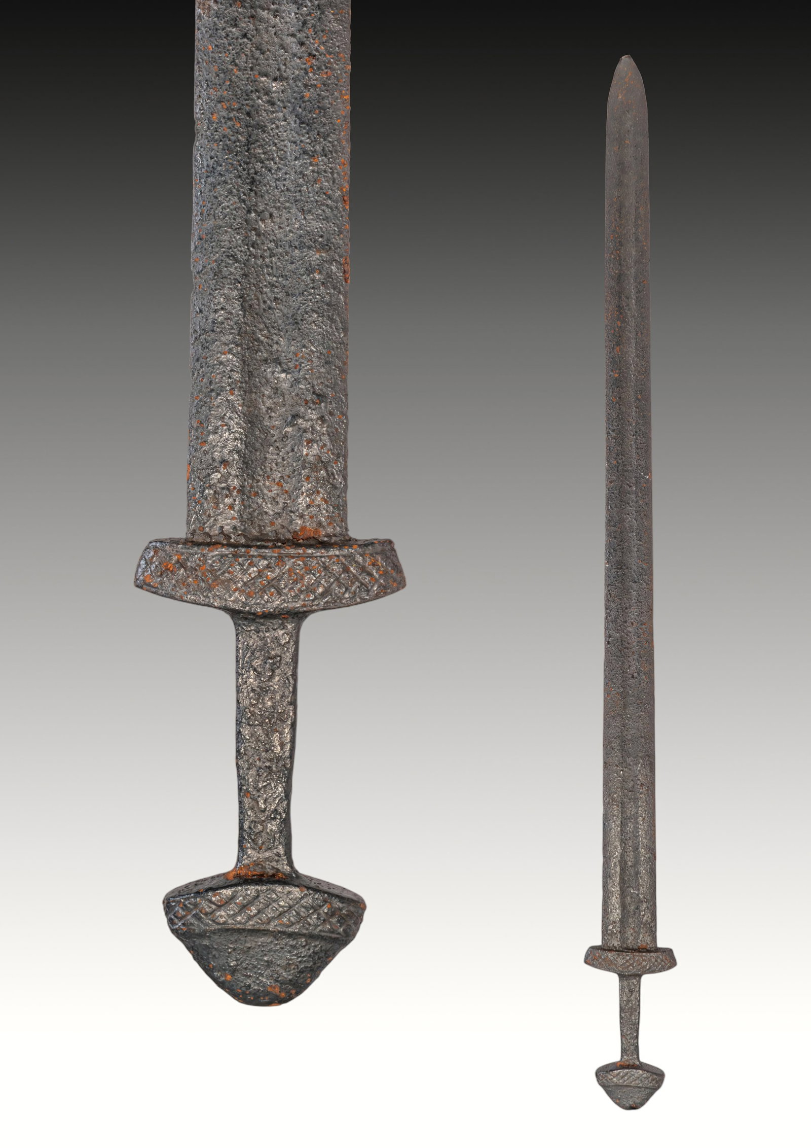 MEDIEVAL VIKING PERIOD IRON SWORD: Ca. AD 750 - 950 . An iron sword with a long, straight double-edged blade tapering to a rounded tip, with a central fuller. A compact short guard separates the blade from the narrow grip. The hilt end