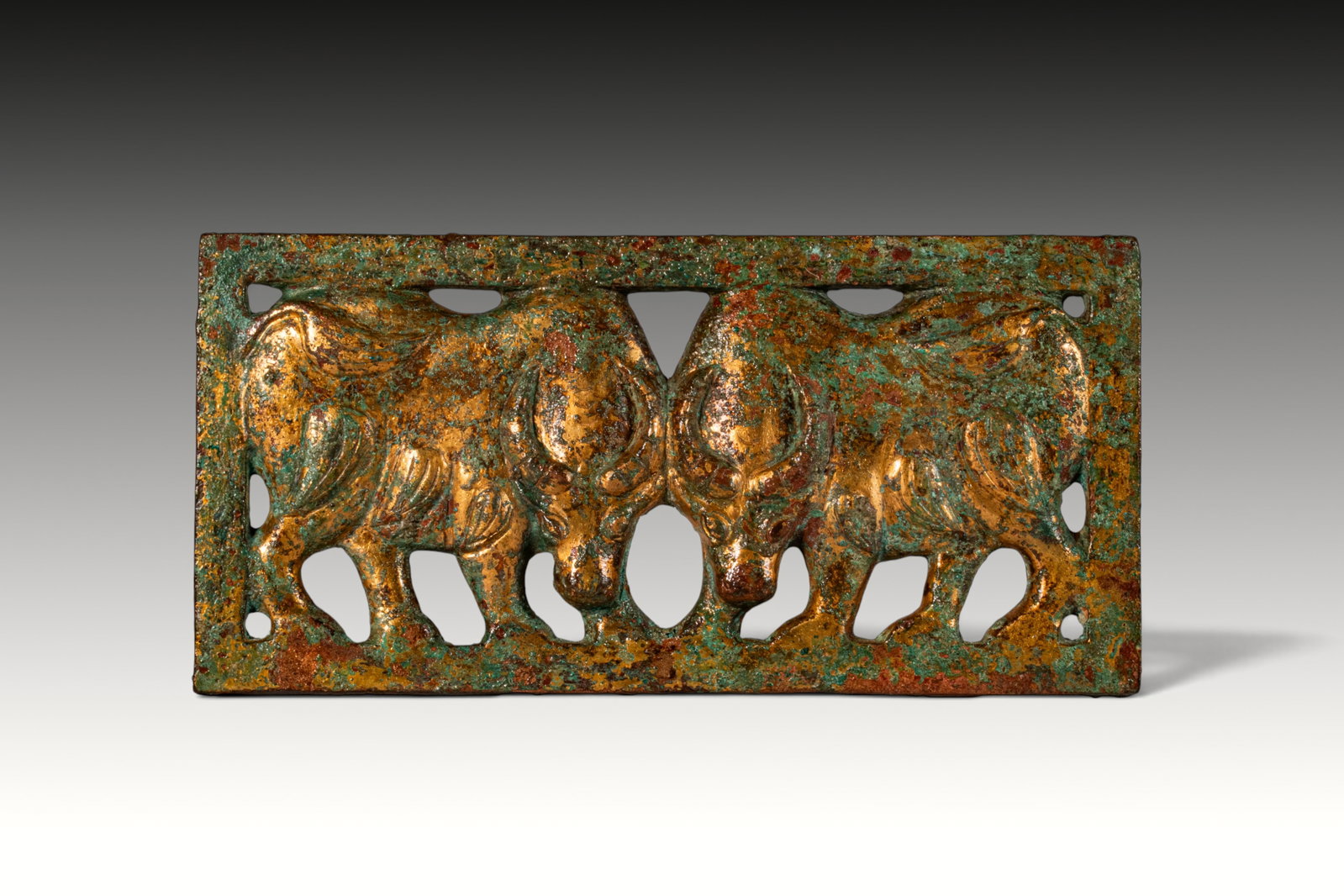 ORDOS CIVILIZATION GILT-BRONZE BELT BUCKLE WITH BULLS: Ca. 300 - 100 BC. A gilt-bronze openwork rectangular belt buckle cast with two opposed bulls within a plain outer frame. Each bull is depicted with lowered head, curved horns, rounded body, and short 
