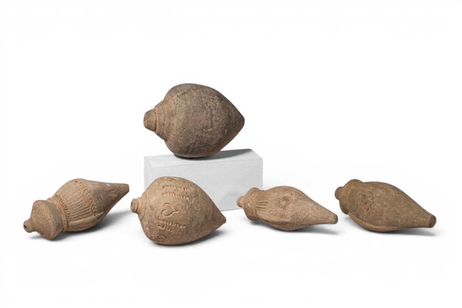 COLLECTION OF BYZANTINE TERRACOTTA GRENADES: Ca. AD 900 - 1300. A collection of five terracotta grenades, including, from top left: a globular vessel with a short neck, rounded mouth, and pointed terminal; a conical example with ribbed shoulder,