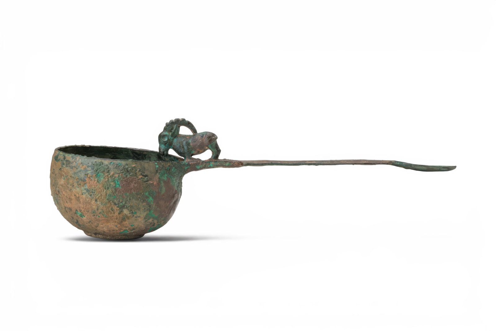 ANATOLIAN BRONZE LADLE WITH IBEX: Ca. 2nd millennium BC. A bronze ladle with a deep rounded bowl and long flat handle terminating in a spoon-shaped finial. At the junction with the bowl is a small ibex figurine with curved horns. Size