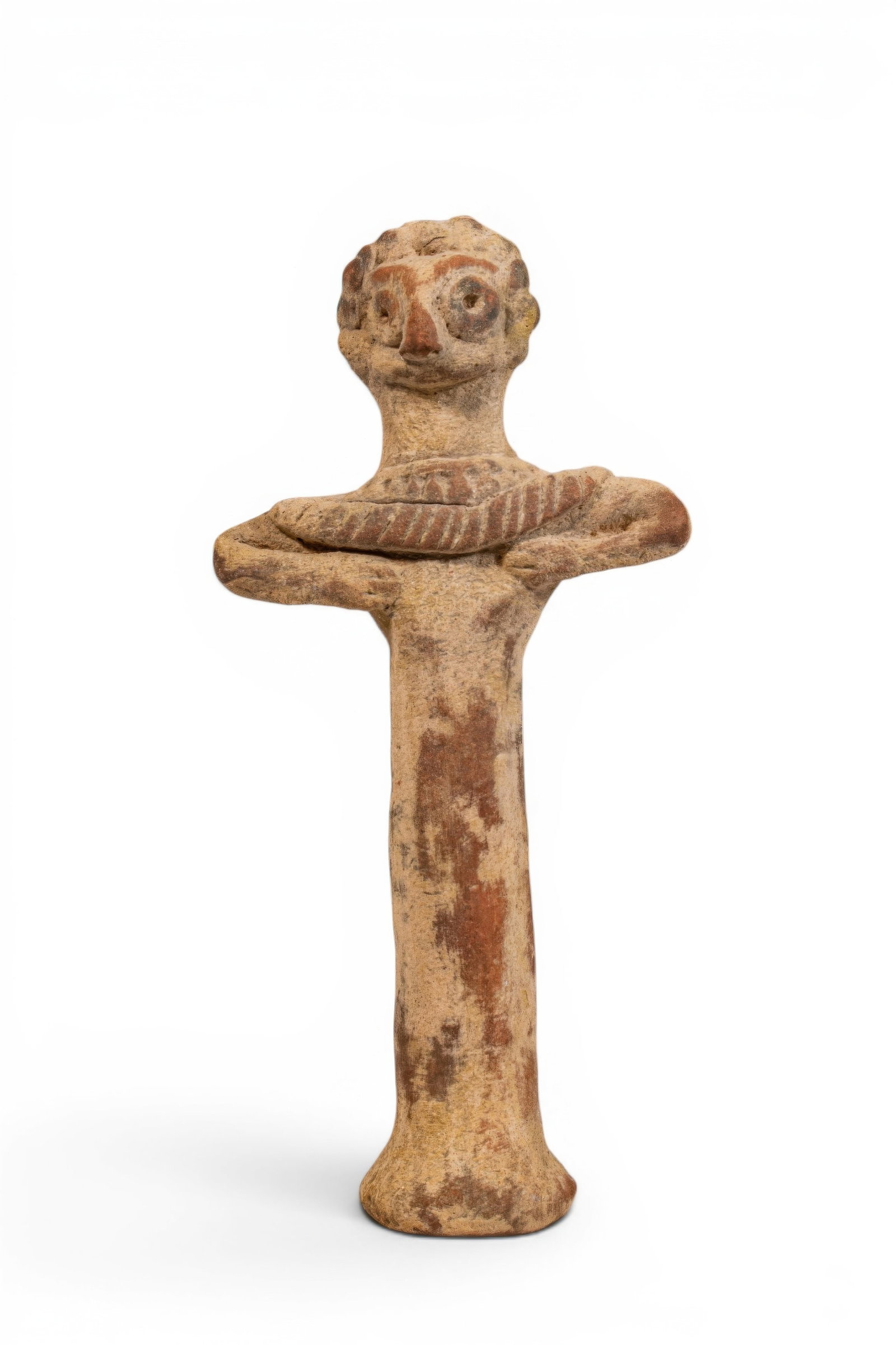 SYRO-HITTITE TERRACOTTA BIRD IDOL: Ca. 2nd millennium BC. A terracotta idol with a tall columnar body, flaring foot, and arms bent outward at the elbows, with the hands held against the chest. The head is modelled with bird-like featur