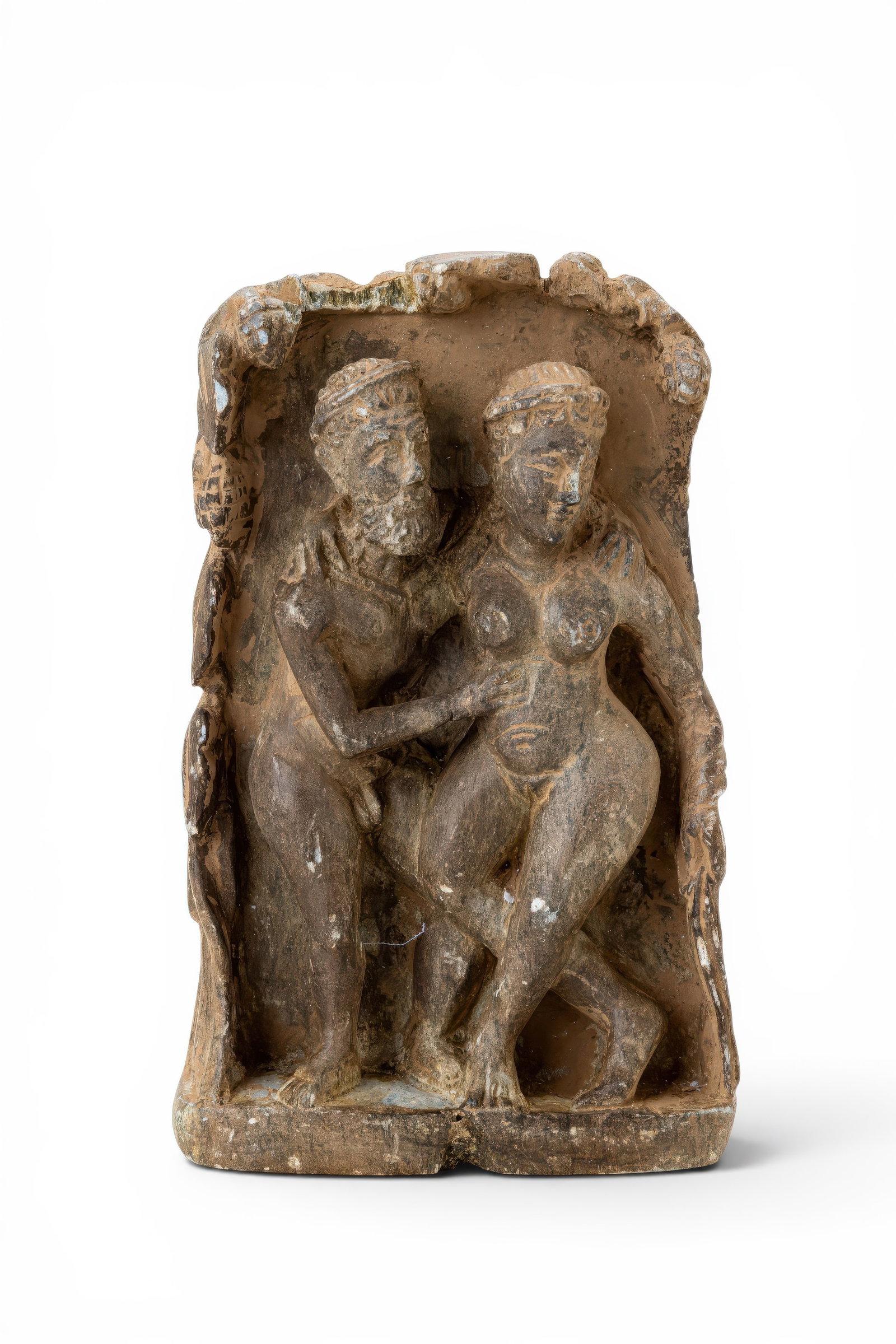 GANDHARA SCHIST RELIEF OF A COUPLE: Ca. 200 BC - AD 200. A schist relief panel with a naked couple within a recessed rectangular frame. The male figure at left has a bearded face and curled hair, with his right arm extending across his 