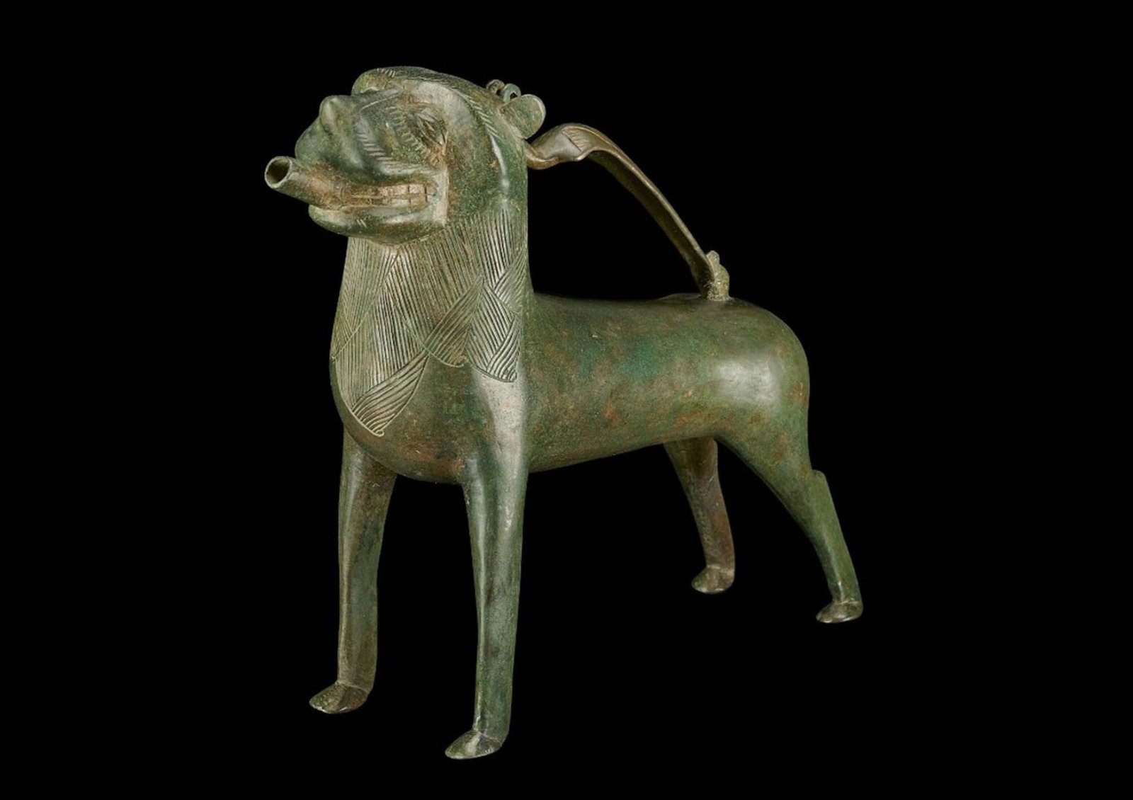 VERY RARE EUROPEAN BRONZE AQUAMANILE IN THE SHAPE OF A LION WITH SUPERB PATINA: Ca. Early 13th century AD. A very rare medieval European aquamanile in the shape of a lion with superb patina. His tail is wrapped between his back legs. Aquamaniles were used to ceremonially wash han