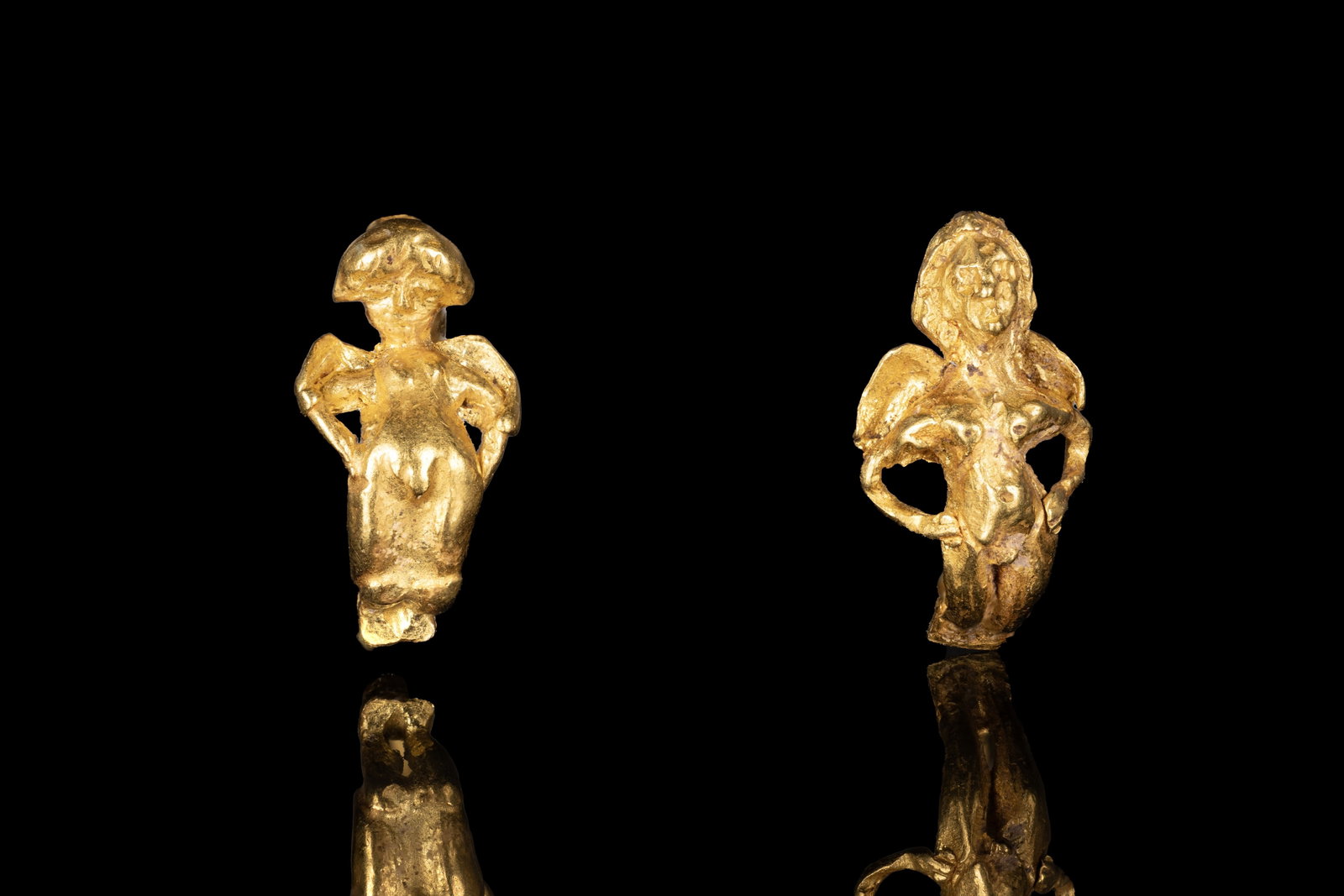PAIR OF HELLENISTIC GOLD EARRINGS WITH EROS: Ca. 250 - 150 BC. A matched pair of gold earrings, each with a winged figure of Eros forming the front and a slender curved hoop extending from the feet to the back of the head. For similar see: The B