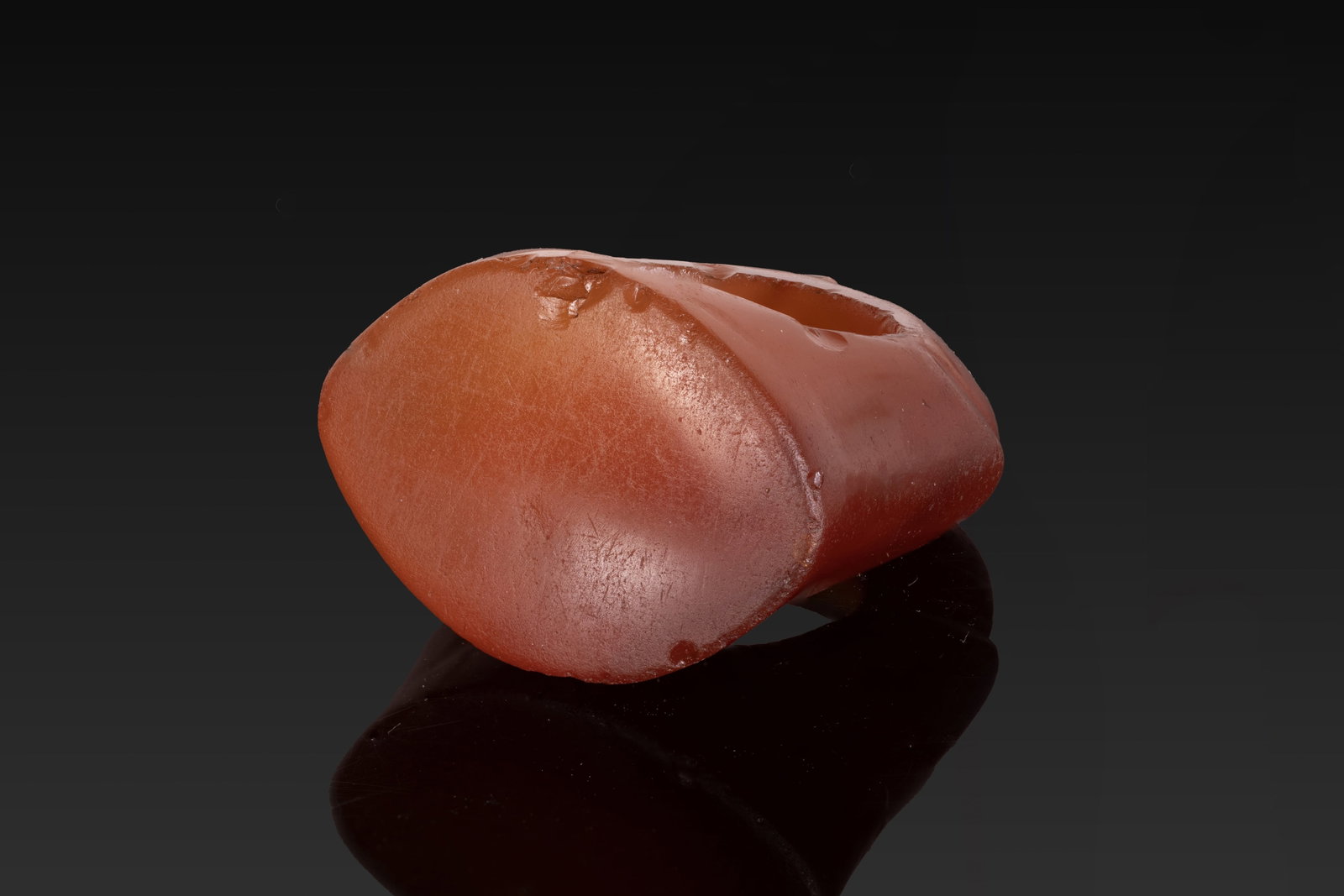 SUPERB ROMAN CARNELIAN RING: Ca. AD 100. A carnelian ring carved in one piece, with a broad, carinated hoop expanding through angular shoulders to an almond-shaped bezel with a plain face. Size: D:14.07mm / US: 2 7/8 / UK: F; Wei
