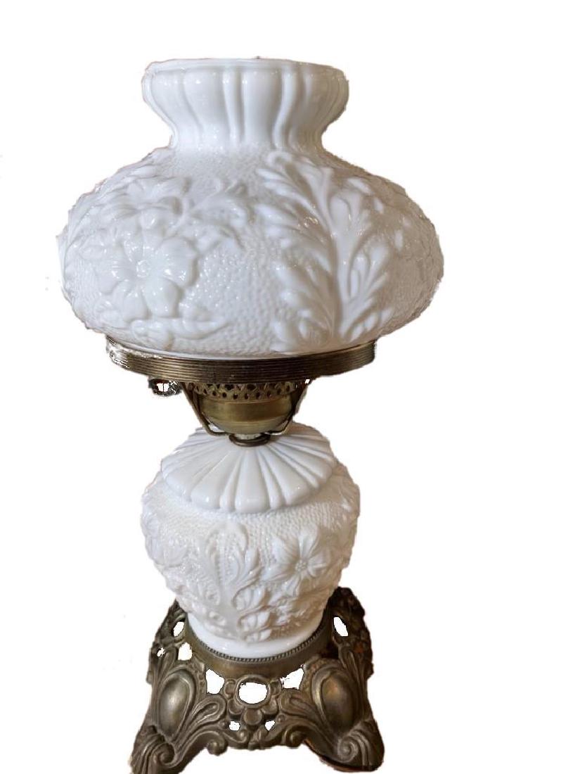 Milk Glass Raised Flower Table Lamp: Milk glass raised flower electric oil lamp. It measures approximately 17" x 9". It has a light inside the base and a socket at the top.