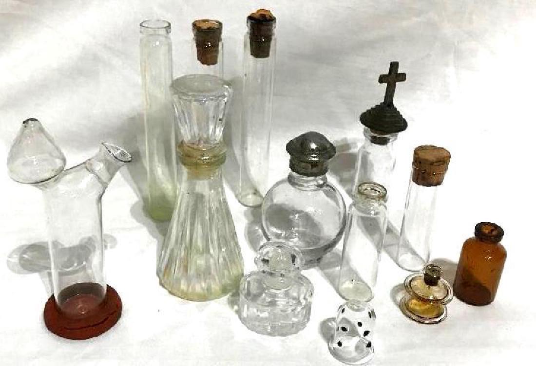 10 Antique Bottles Beakers Perfume Medicine: This lot contains 10 pieces of antique pieces of glass ware. There are small beaker type cylinders, medicine and perfume bottles and a nasal douche.