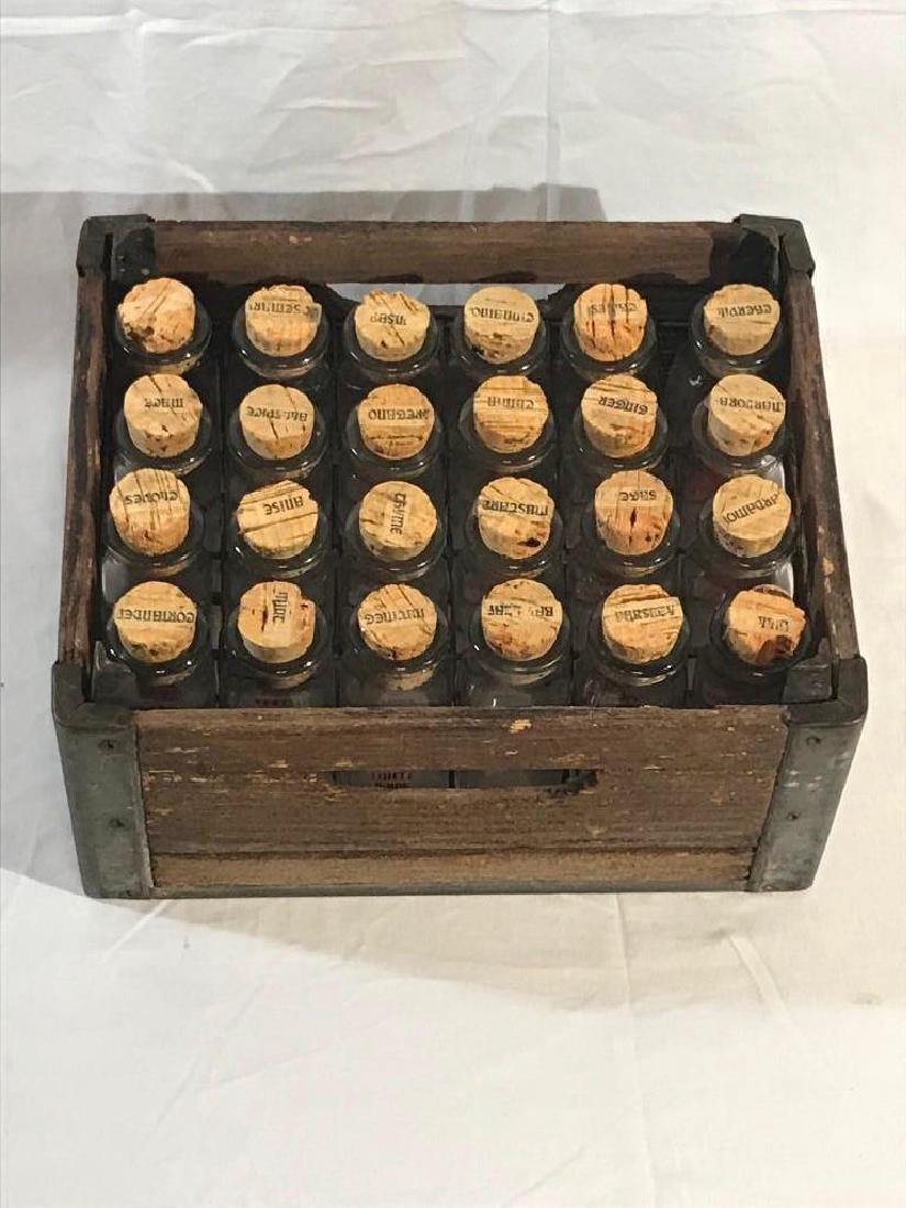 Milk Bottles and Crate Spice Set: 24 1/2 pint glass milk bottles from Thiel Dairy in a wood and metal milk crate marked Clover Leaf. The bottles have corks with labels for different spices and seasonings. The bottles measure appro