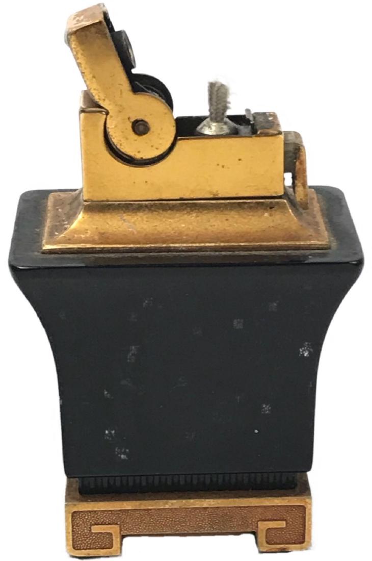 Black Bakelite Art Deco Lighter: This table lighter features a pagoda style design in gold and black. It is made of bakelite and metal and appears to be in very good condition. It was made by A.S.R. Corp Brooklyn around the 1940's. I