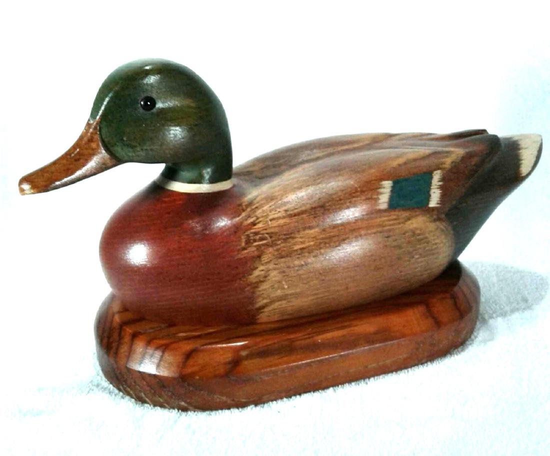 1984 R.D. Lewis Carved Decoy Mallard Duck With Stand: A 1983 R.D. Lewis Carved Decoy Mallard Duck Drake With Stand and a glass eye is in very good condition with a couple small scratches as shown in the photos. The wood carving measures approximately 14.