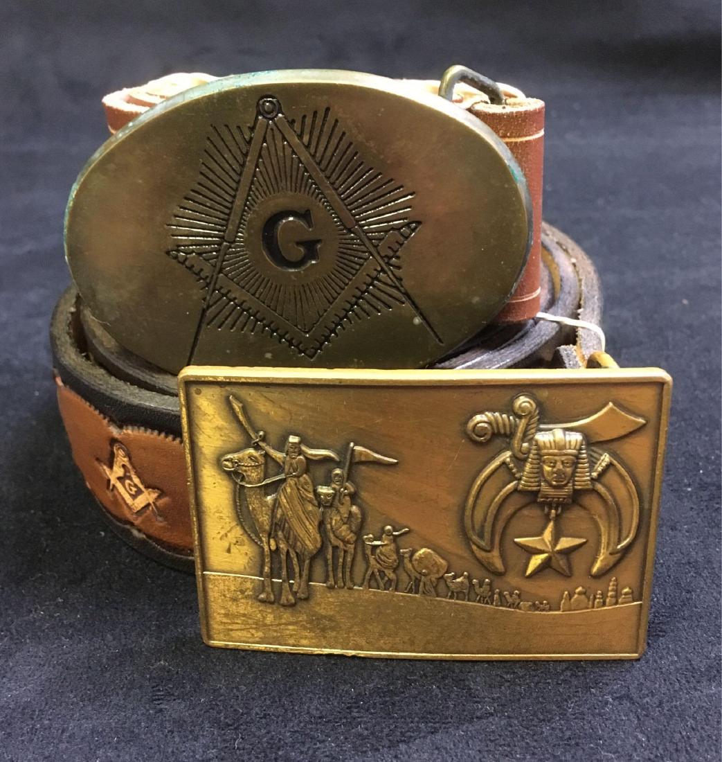 Vintage Mason Leather Belt Lot: Fraternal order of the Freemasons, leather belt and buckle lot of 2. Featuring one 46" belt, tan and black with symbols and the name Terry. Also, one plain tan belt 49" long. Both belts have decorativ