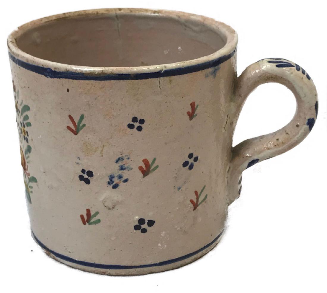 Vintage Small Hand-painted Earthenware Cup: Vintage Small Hand-painted Earthenware Cup; this small cup appears primitive in workmanship except for the fine hand-painted scene. The scene shows a woman in peasant garb (Dutch?) surrounded by a gar