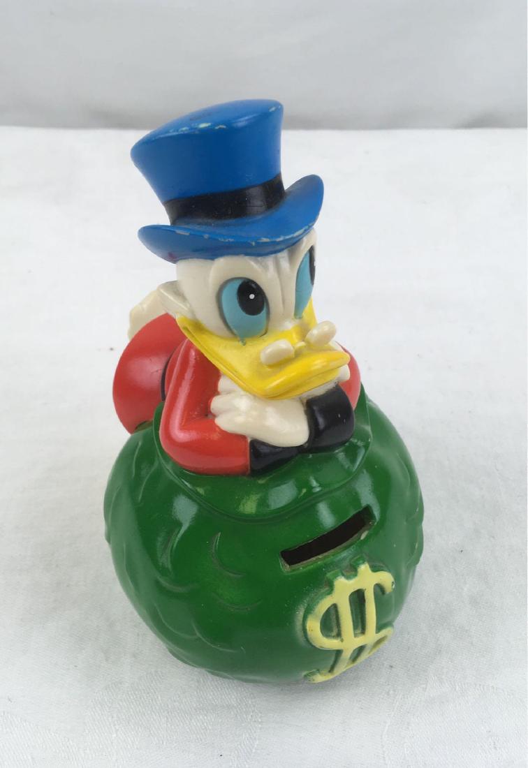 Vintage Scrooge McDuck Piggy Bank Walt Disney: Scrooge McDuckÂ child's piggy bank, composed of rubber and made in Korea. Stopper is present and piece is in good overall, but used condition. Measures approx. 6" H, 4" W.